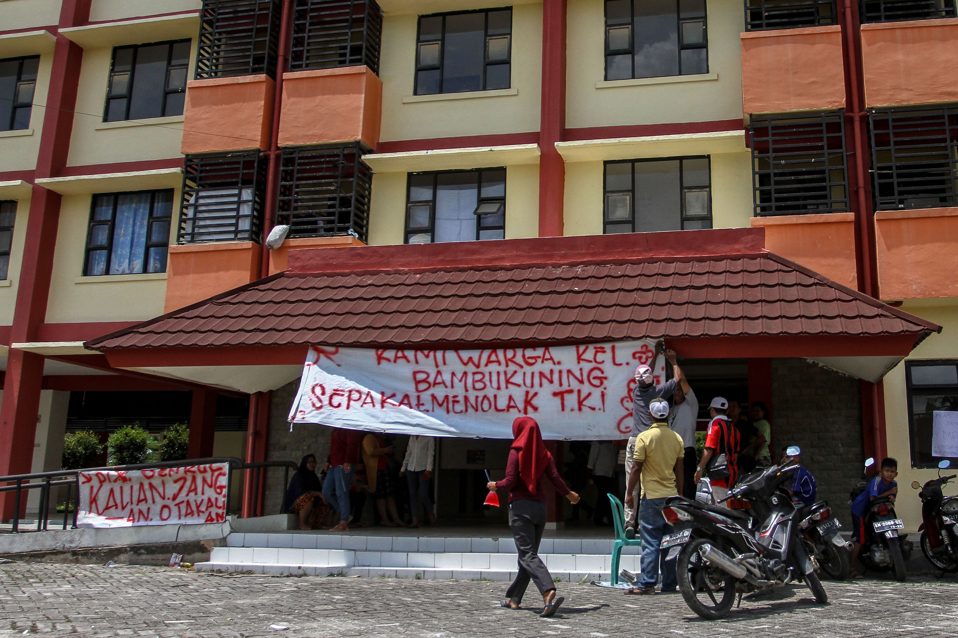 Warga memasang spanduk di depan Rusunawa Rejosari di Kelurahan Bambu Kuning, Pekanbaru, Riau, Senin (30/3/2020)