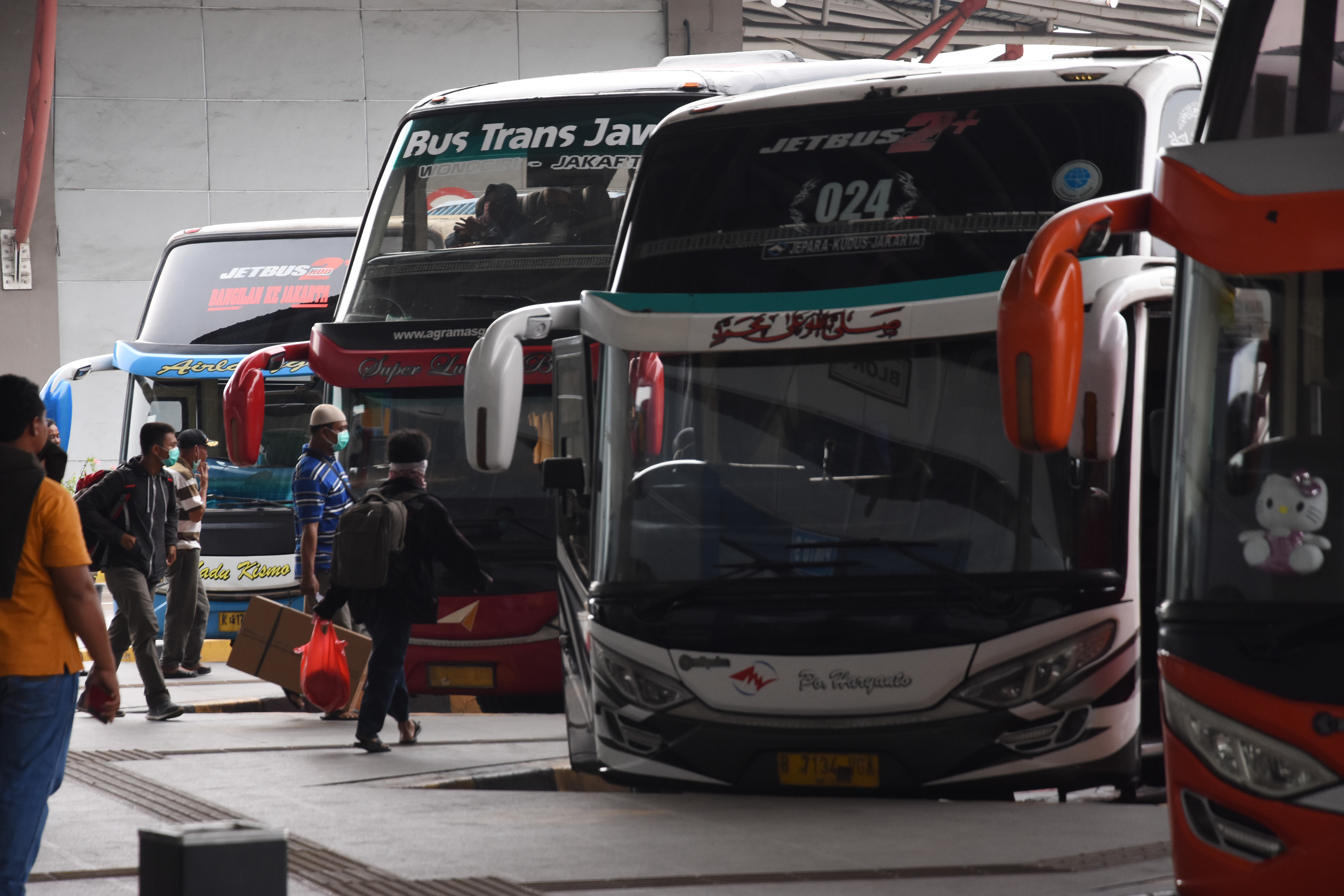 Calon penumpang bersiap menaiki bus Antar Kota Antar Provinsi di Terminal Pulo Gebang, Jakarta, Minggu (29/3).