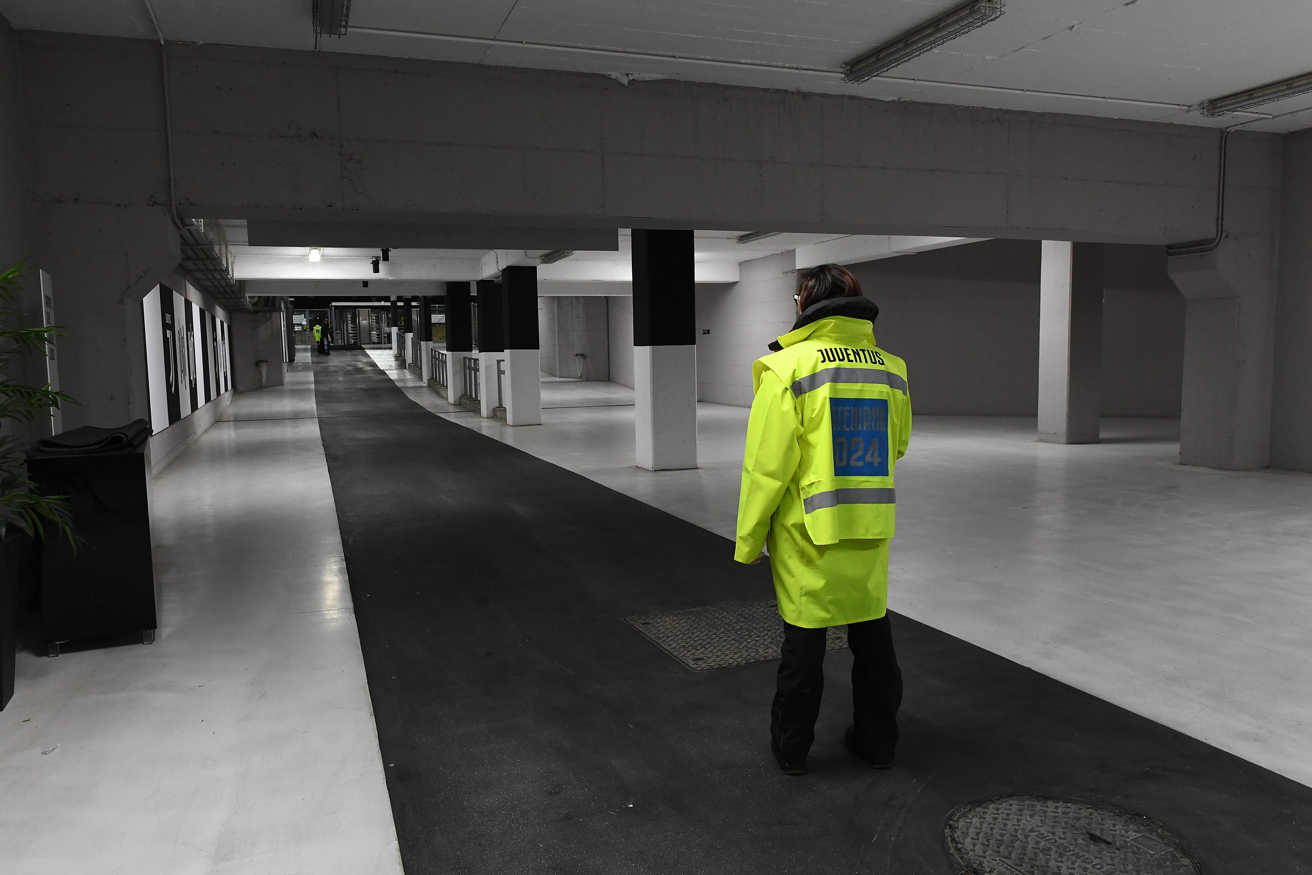 Seorang petugas keamanan berjaga-jaga di dalam Stadion Allianz, markas Juventus, yang kosong.
