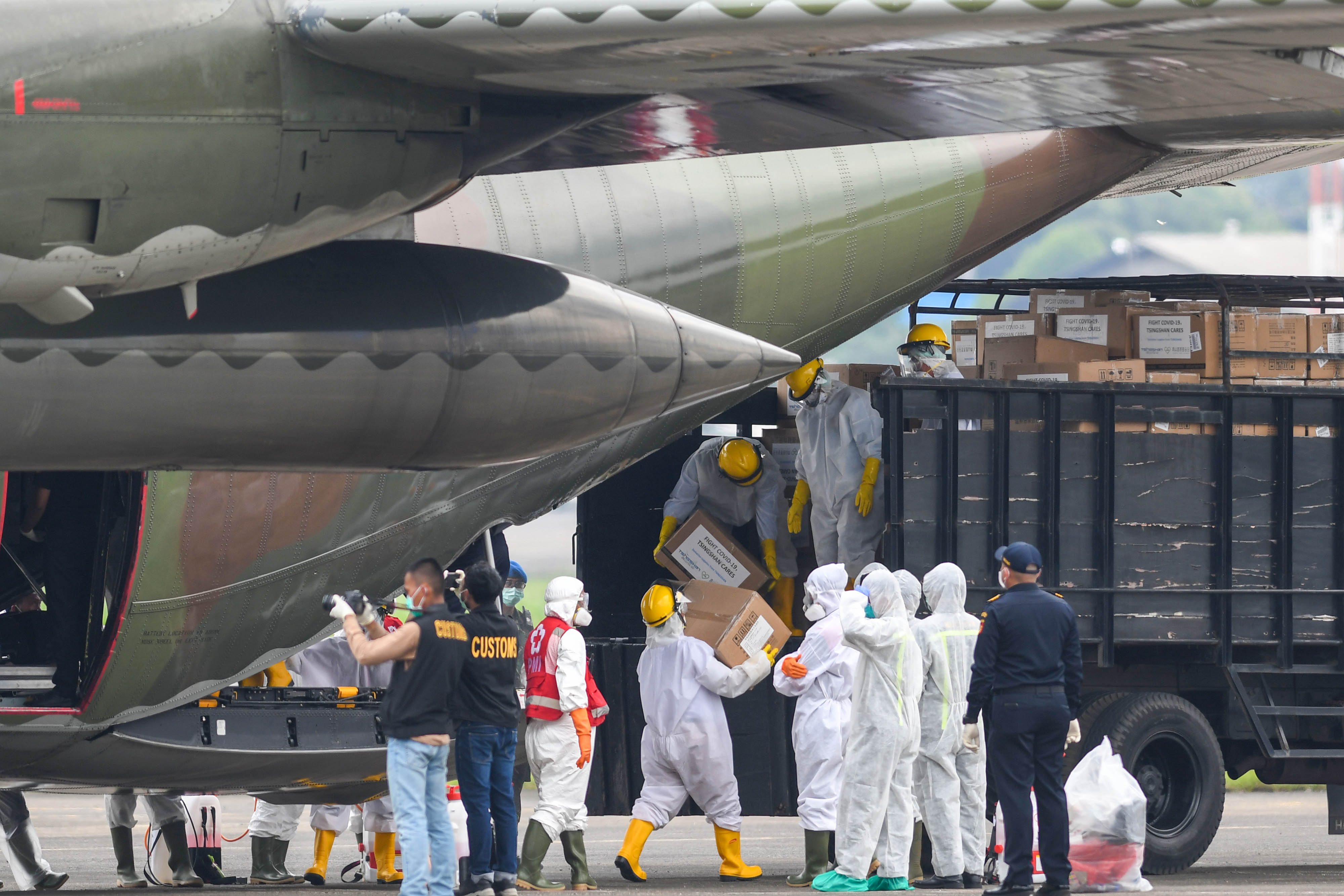 Petugas memindahkan kardus berisi alat kesehatan dari Tiongkok untuk penanganan Covid-19, yang diangkut pesawat C-130 Hercules TNI AU.