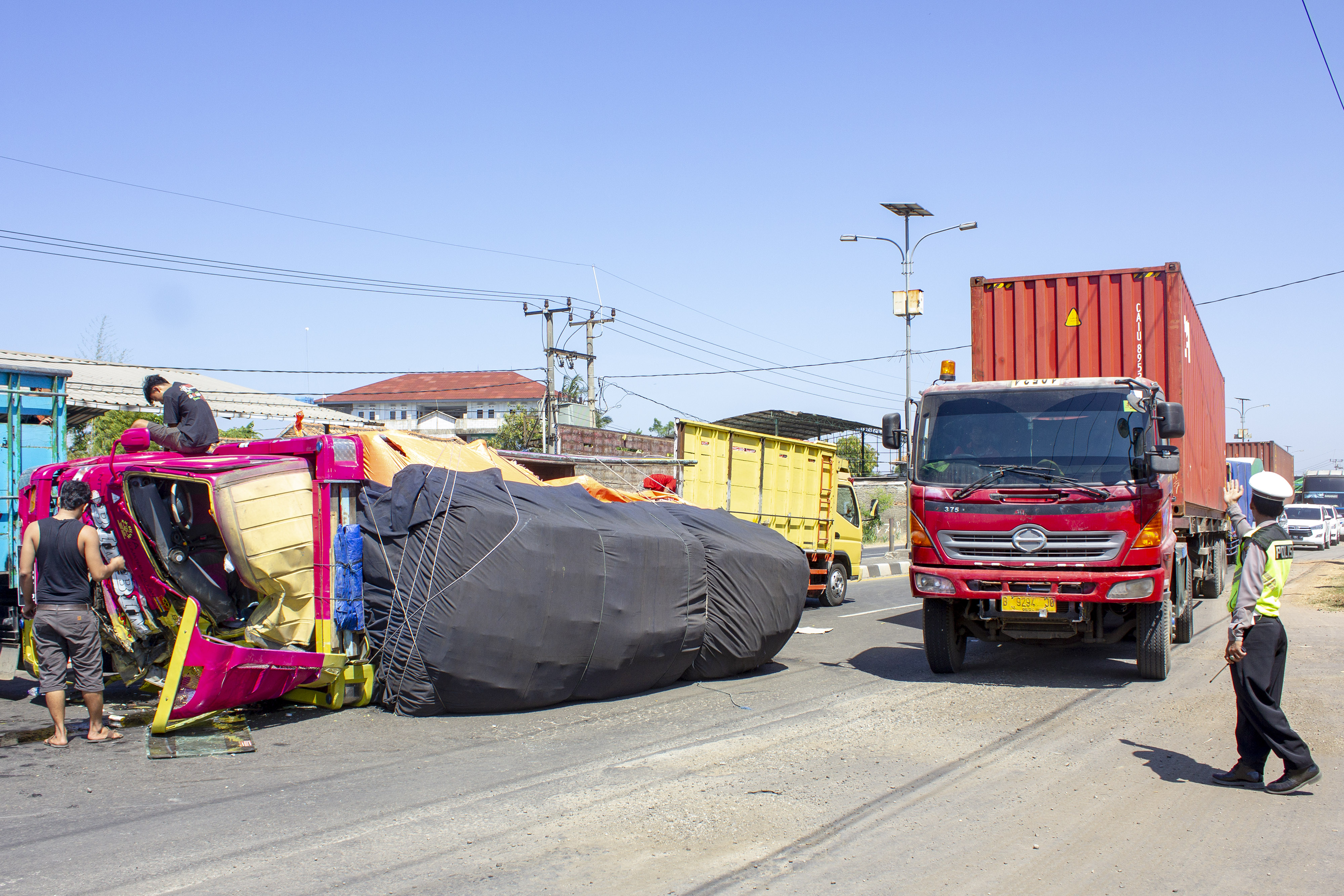 Sebuah truk dengan muatan berlebihan terguling di Jalur Pantura Jatisari, Karawang, Jawa Barat. 