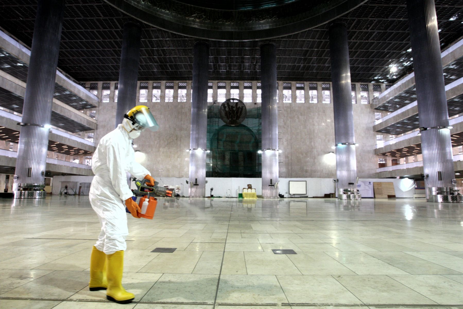 Petugas menyemprotkan cairan disinfektan untuk mencegah penyebaran virus korona.