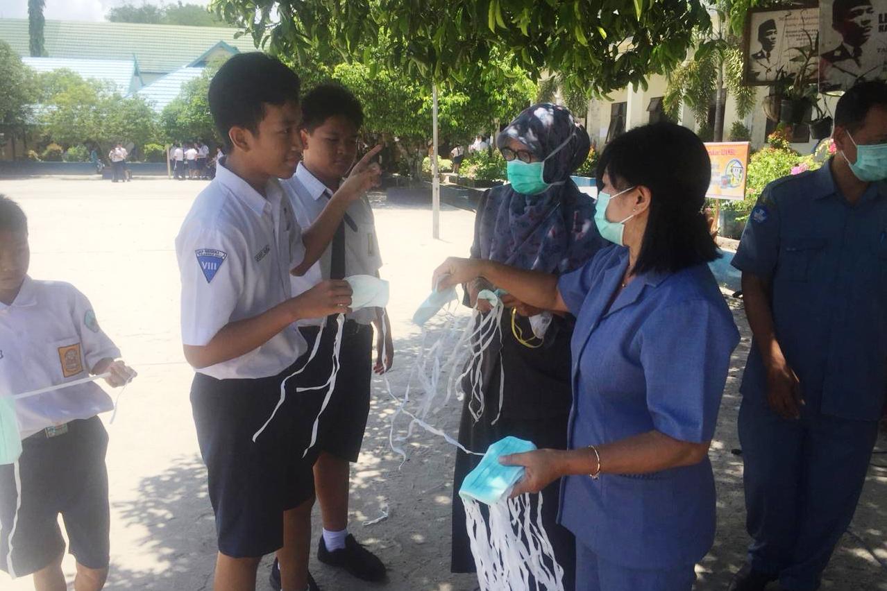Guru di Palangka Raya membagikan masker kepada para siswanya untuk tangkal penyebaran covid-19.