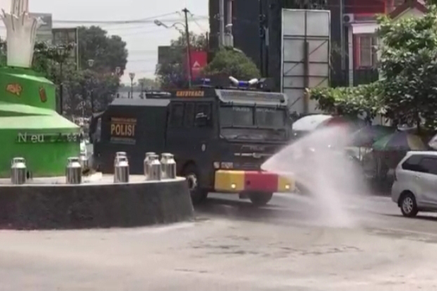 Polres Boyolali membersihkan debu Merapi di jalanan Boyolali dengan menyemprotkan air lewat Rantis Gatot Koco.
