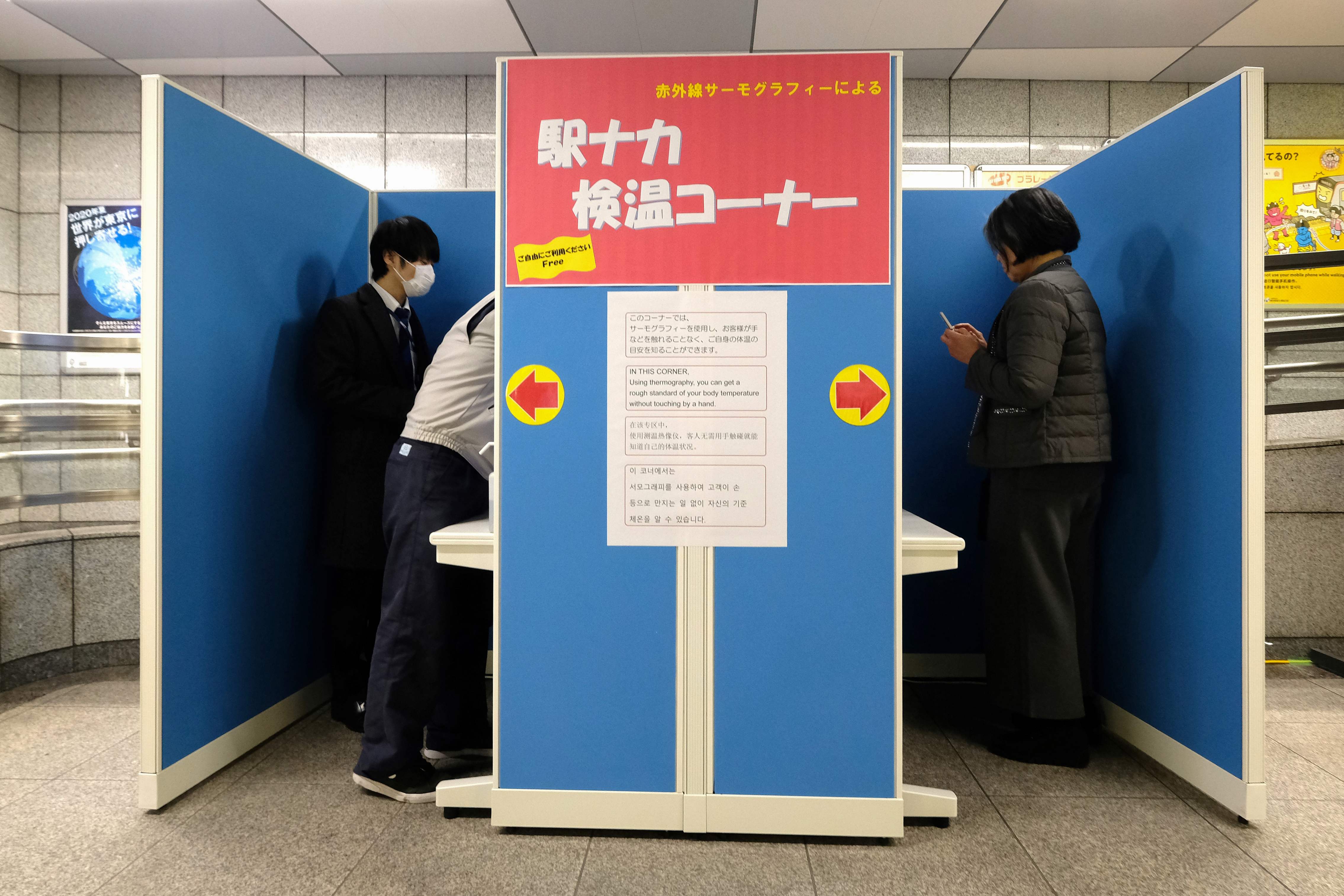 Para pelancong diperiksa suhu tubuhnya di Stasiun Tocho-mae, Tokyo.