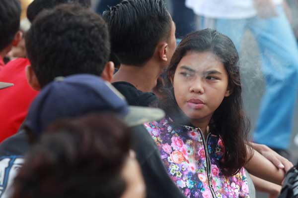Remaja merokok saat hari bebas kendaraan bermotor di kawasan Bunderan Hotel Indonesia, Jakarta, Minggu (6/9).