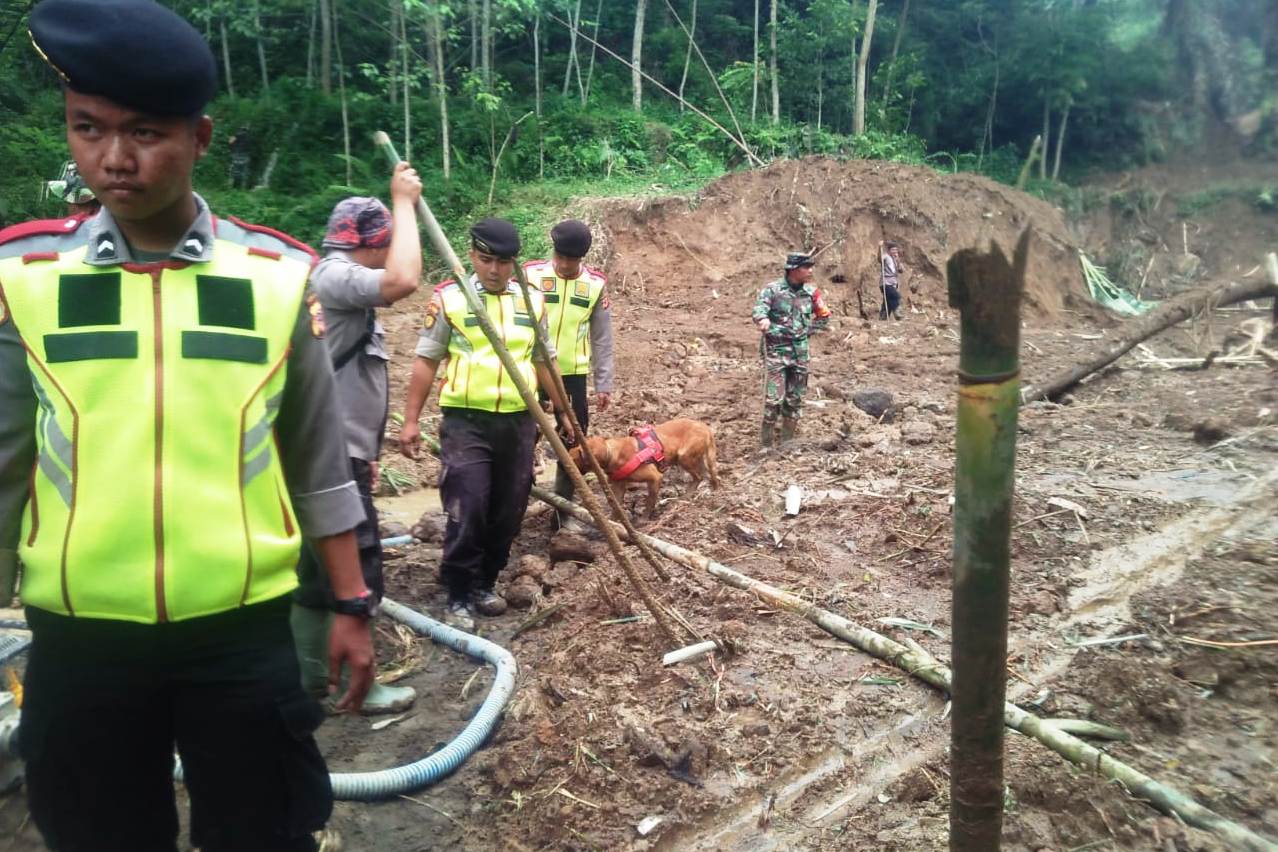 Dua Polisi pawang anjing pelacak K-9 dari Polda Jabar, diturunkan untuk melakukan pencarian korban longsor di Desa Santanamekar, Tasikmalaya