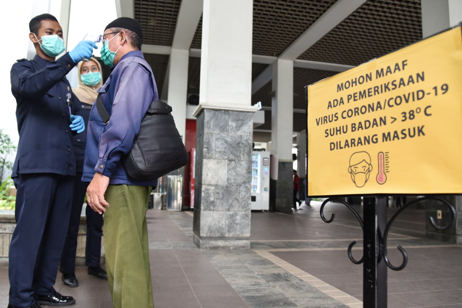 Petugas mengecek suhu tubuh aparatur sipil negara (ASN) maupun warga yang memasuki area Balai Kota, Jakarta.
