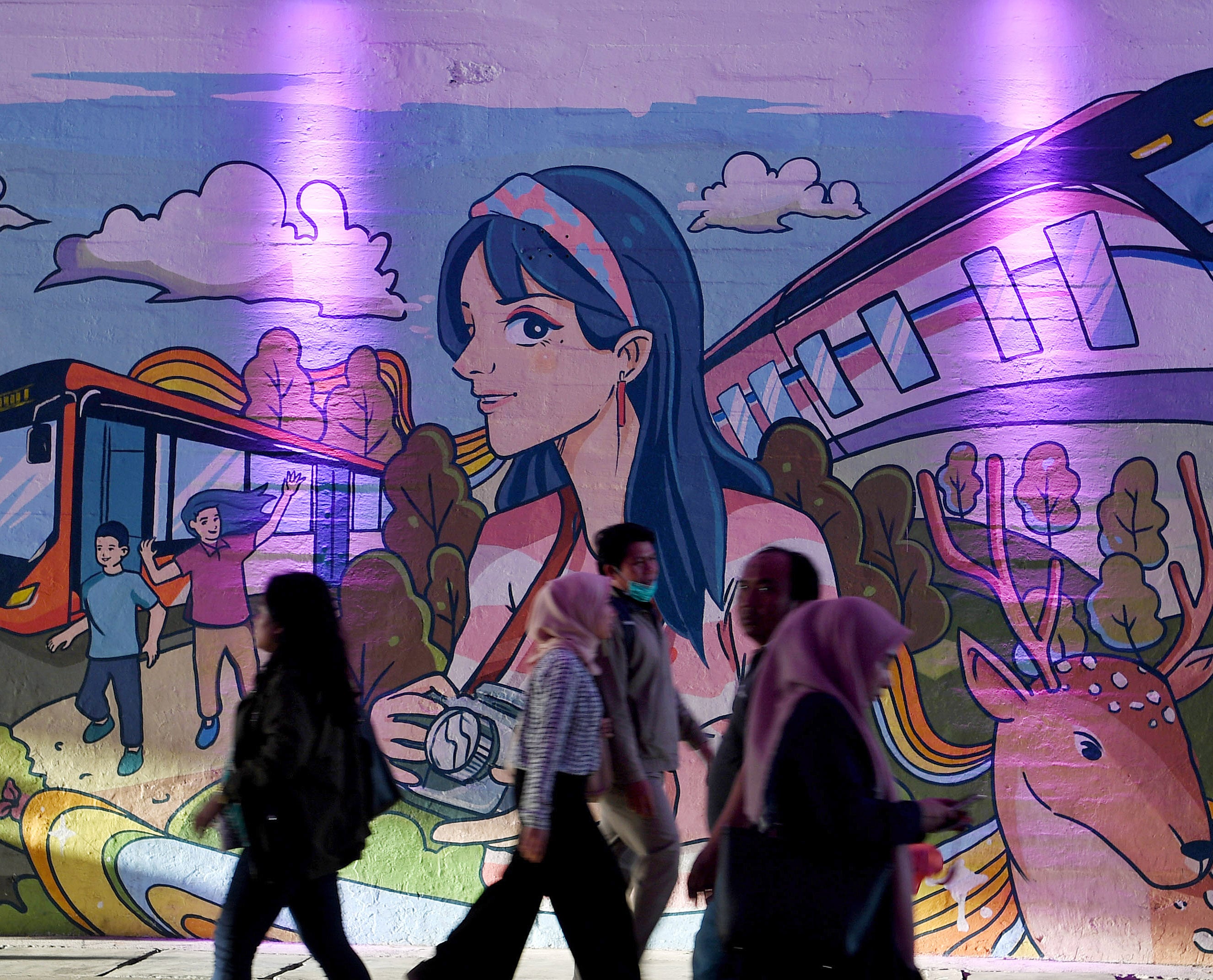 Sejumlah warga melintasi mural bertema transportasi publik di terowongan jalan Kendal, Tosari, Jakarta.