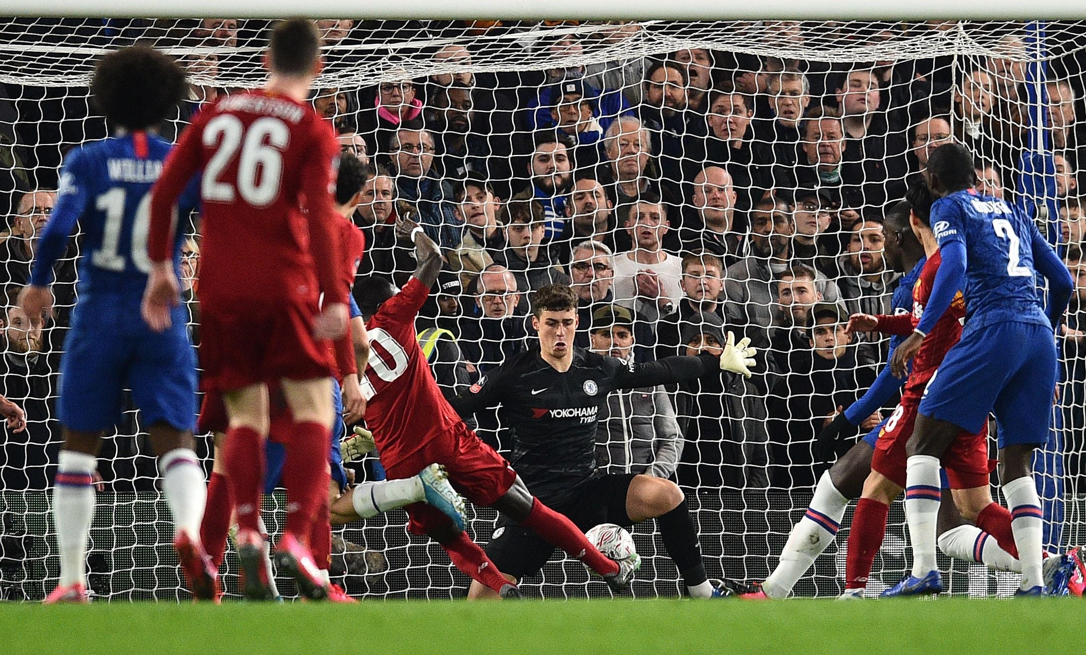 Kiper Chelsea asal Spanyol, Kepa Arrizabalaga (C) menyelamatkan tembakan dari striker Liverpool Senegal Sadio Mane (tengah L)  