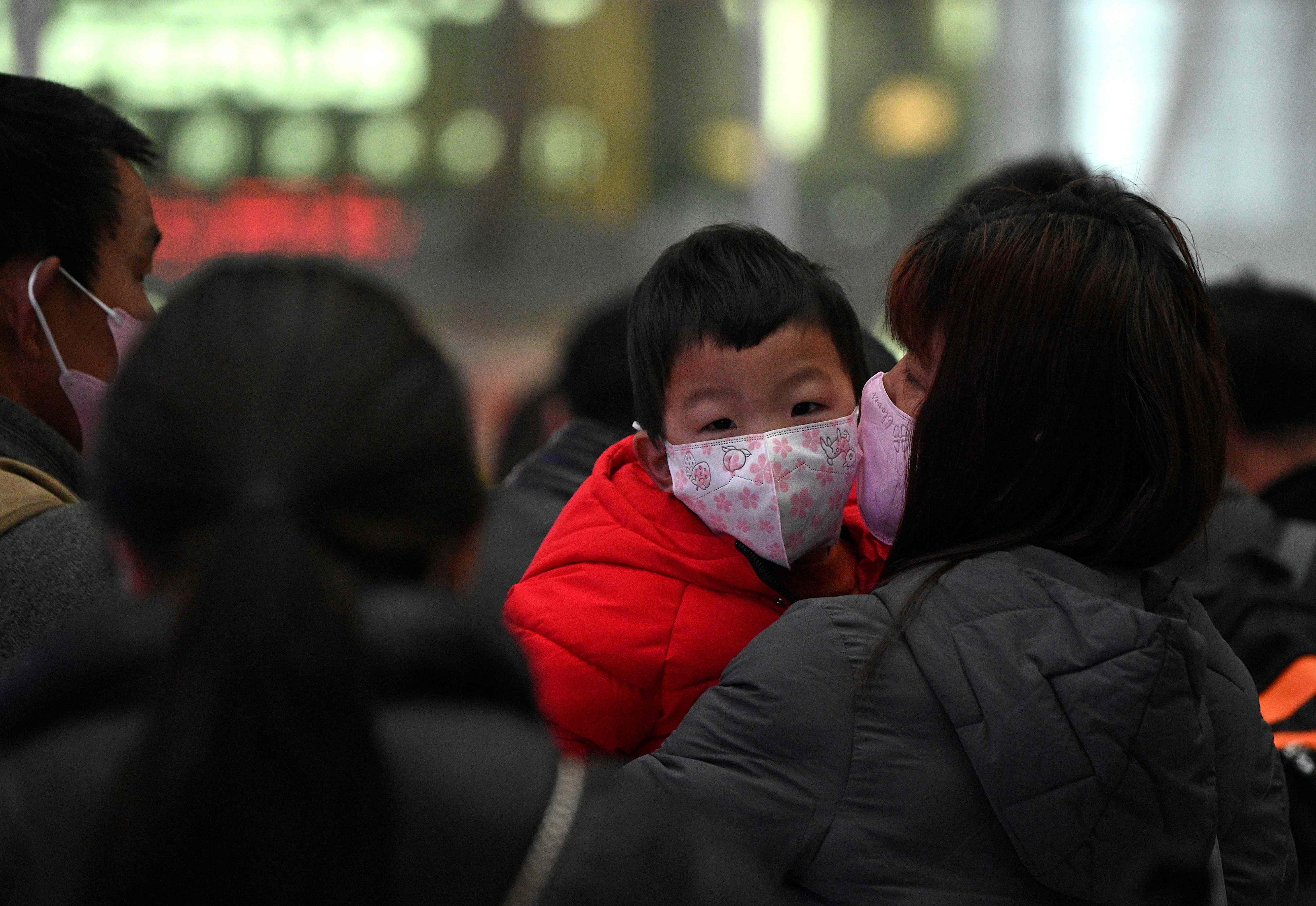 Sejumlah orang mengenakan masker saat berada di stasiun kereta Hefei, Provinsi Anhui, Tiongkok.