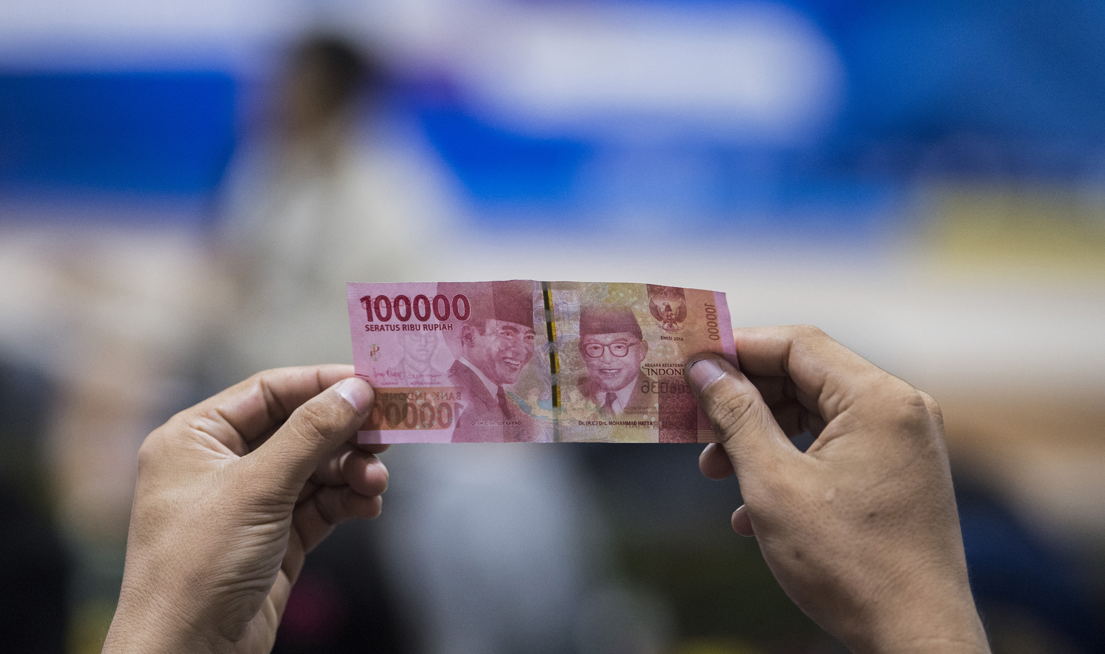 Warga menerawang uang rupiah saat sosialisasi Quick Response Code Indonesia Standard (QRIS) Nasional 2020.