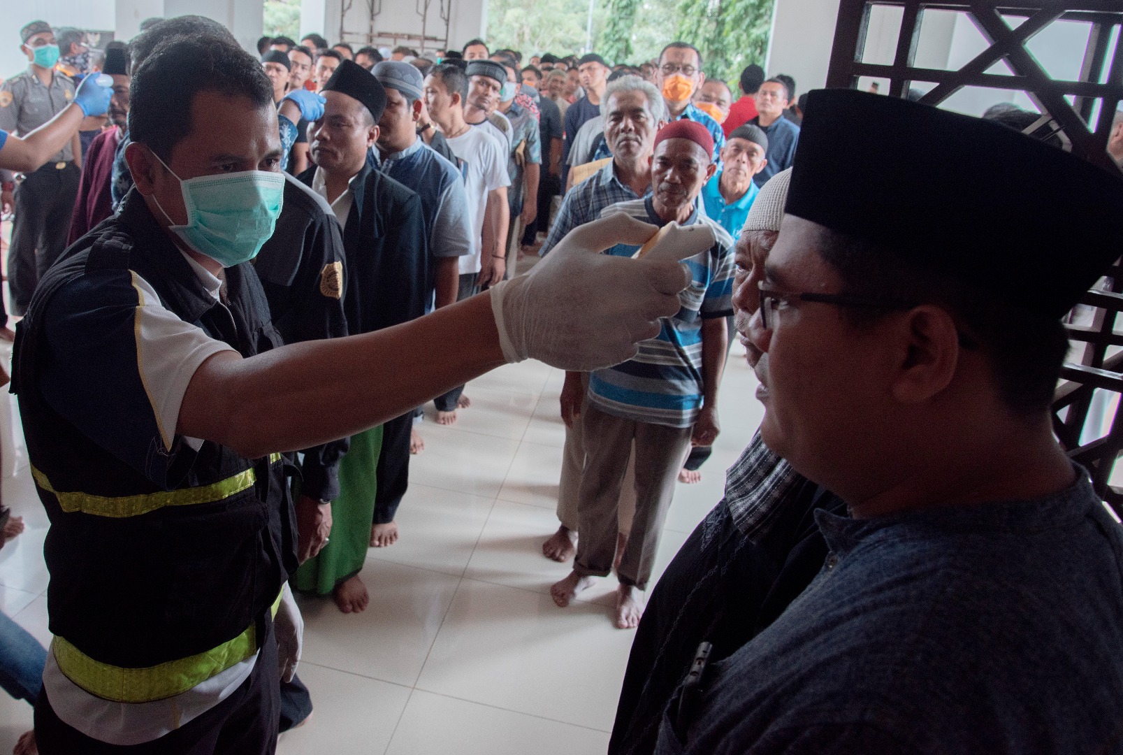 Petugas mengukur suhu tubuh warga sebelum melaksanakan Salat Jumat di masjid Agung Sukabumi, Jawa Barat, Jumat 27/3/2020