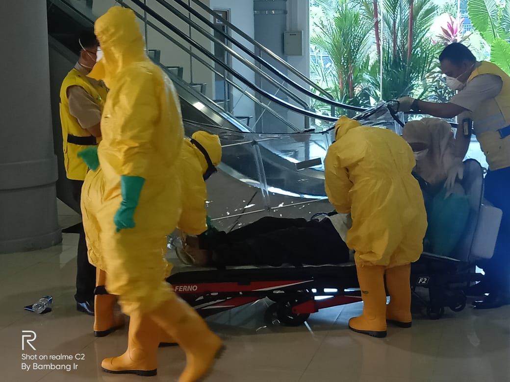 Jemaah umrah yang diduga suspek korona dievakuasi oleh petugas medis di Bandara Sultan Mahmud Badaruddin II, Palembang, hari ini.