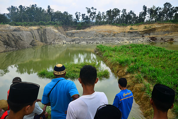 Warga menyaksikan tempat galian C lokasi tenggelamnya santri dan seorang Kyai di Dusun Sobotuwo, Kronggen, Brati, Grobogan, Jawa tengah.