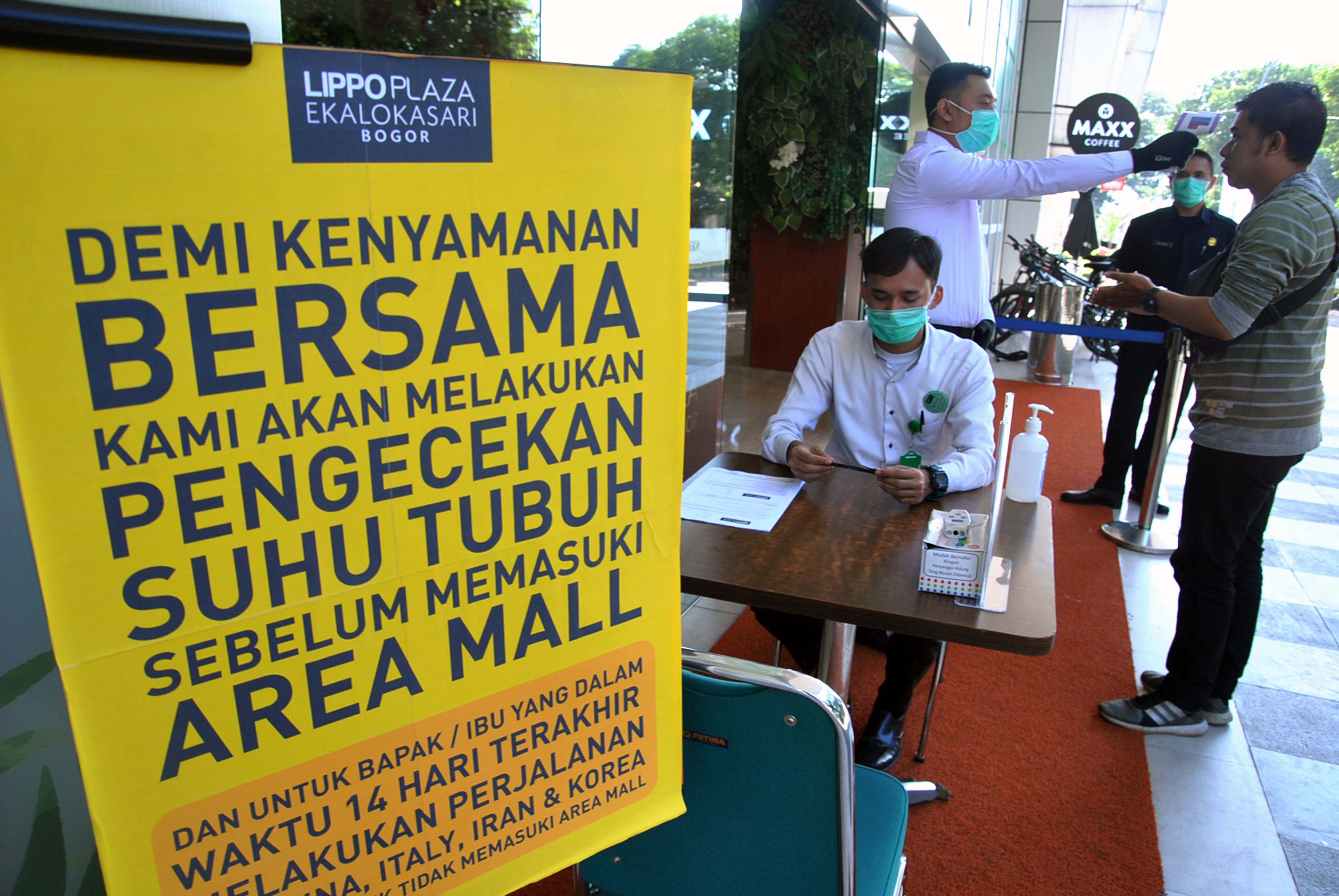 Petugas memeriksa suhu tubuh pengunjung Lippo Keboen Raya, Kota Bogor, Jawa Barat, beberapa waktu lalu. 