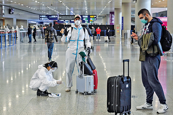 Penumpang mengenakan alat pelindung di tengah kekhawatiran virus korona (covid-19) saat tiba di Bandara Internasional Pudong Shanghai.