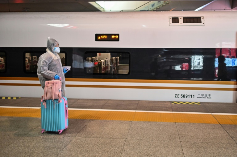 Seorang penumpang perempuan turun di lokasi pemberhentian di Kota Wuhan setelah penerapan lockdown diakhiri. 