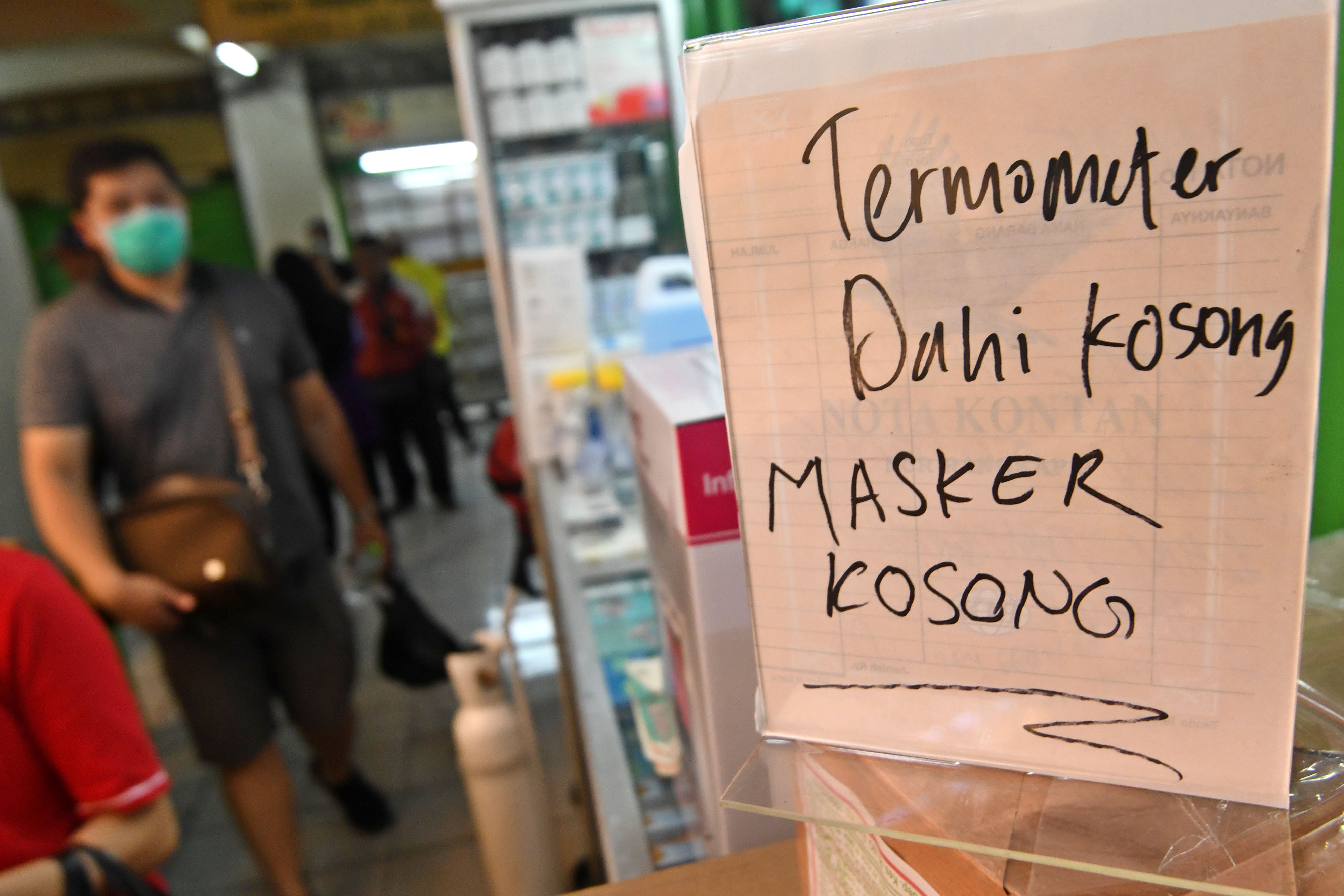 Pedagang Pasar Pramuka memasang pengumuman masker yang dijualnya habis karena diserbu pembeli
