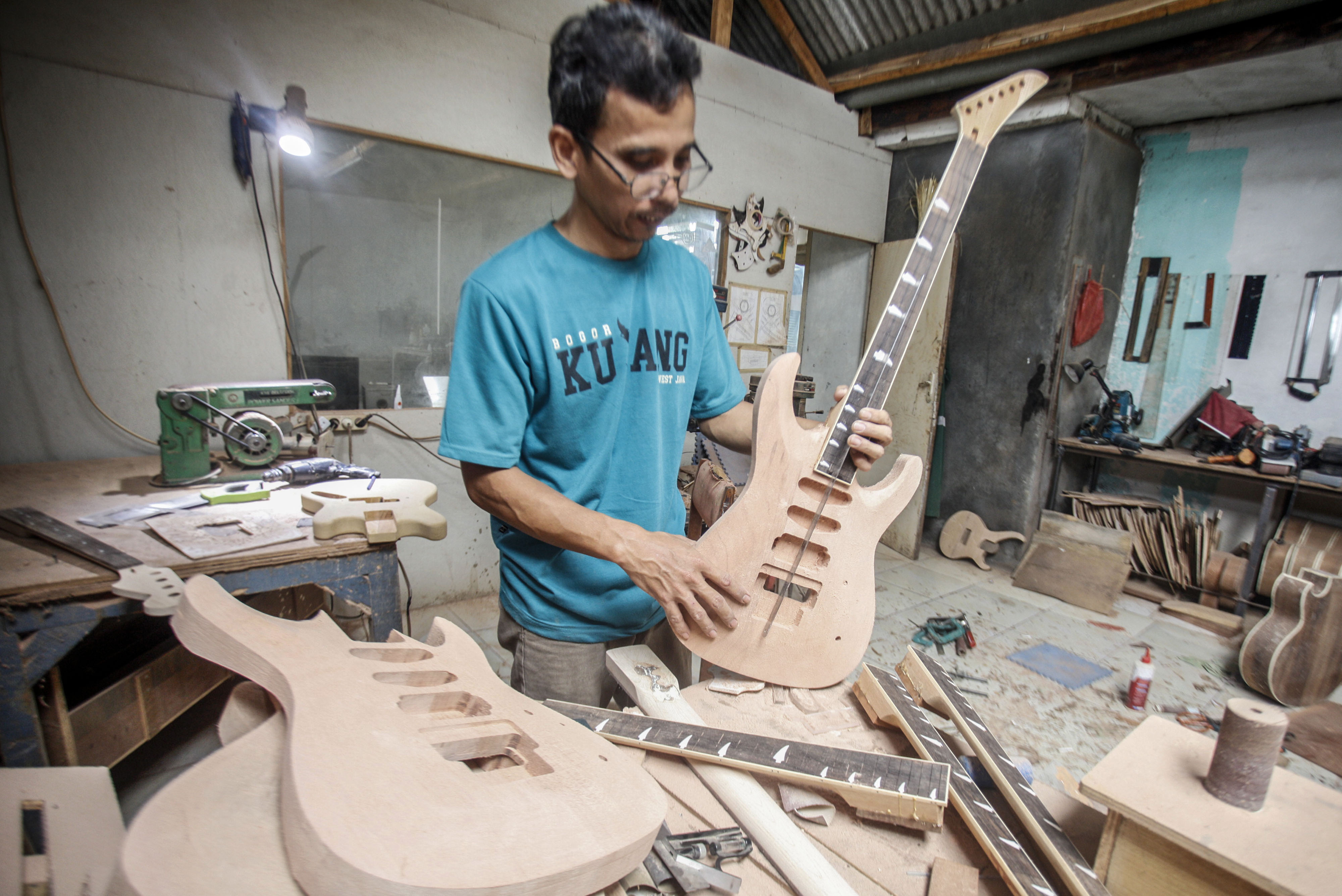  Perajin menyelesaikan pembuatan gitar  di sentra produksi gitar rumahan Arya Guitar Custom di kawasan Klapanunggal,  Bogor, Jawa Barat.