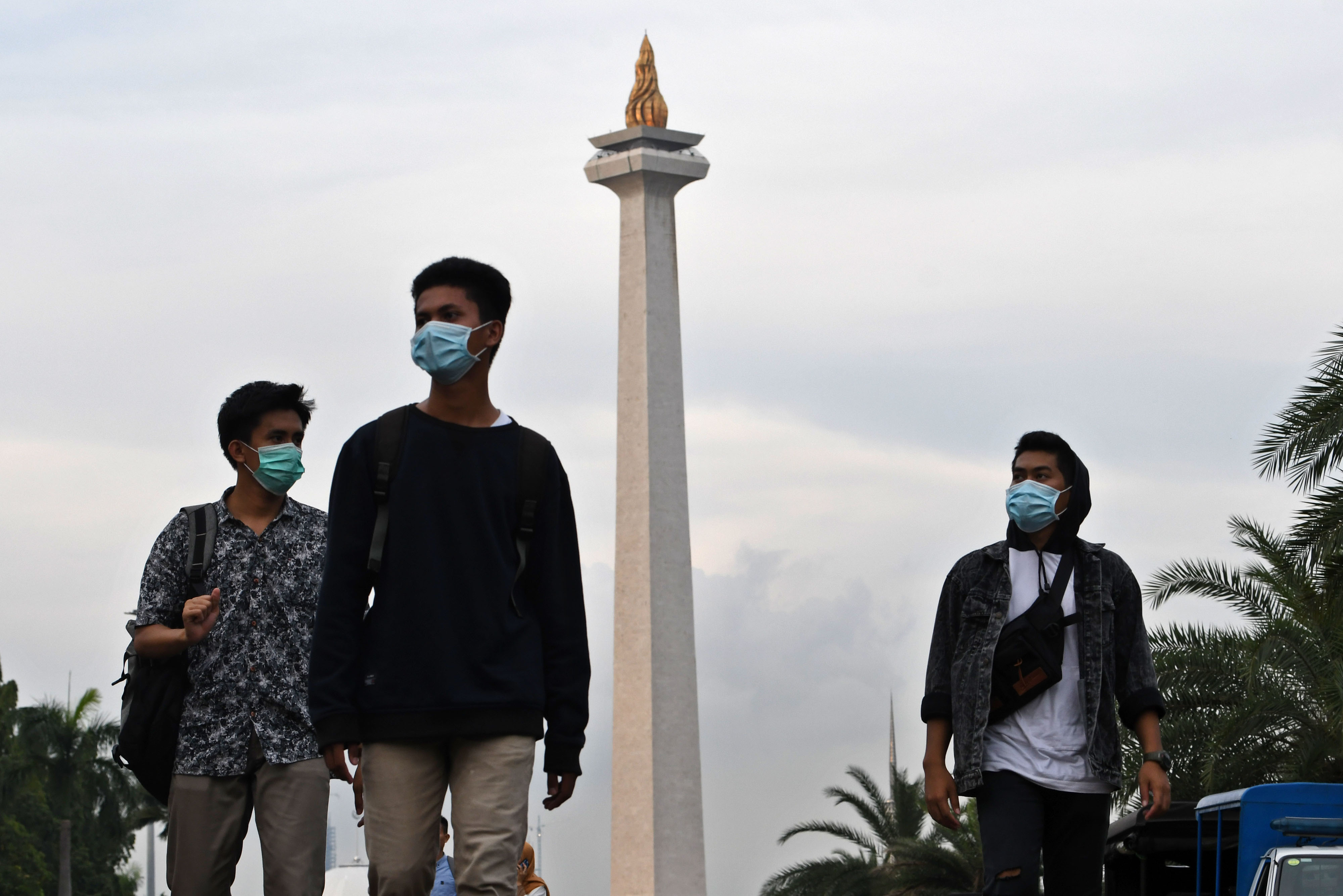 Pengunjung monas menggunakan masker untuk mencegah penyebaran virus korona