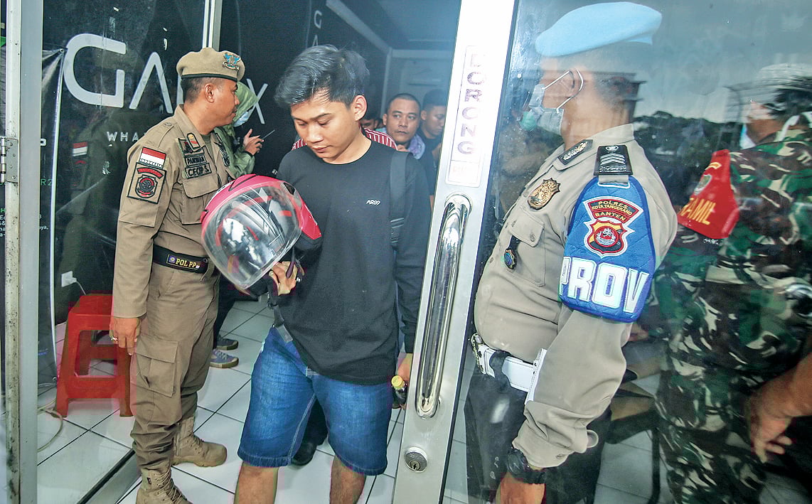 Anggota Satpol PP dibantu TNI dan Polri membubarkan warga saat razia warung internet (warnet) di Panongan, Kabupaten Tangerang, Banten,.