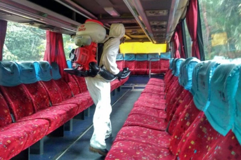 Petugas menyemprotkan disinfektan di dalam bus kuning UI.