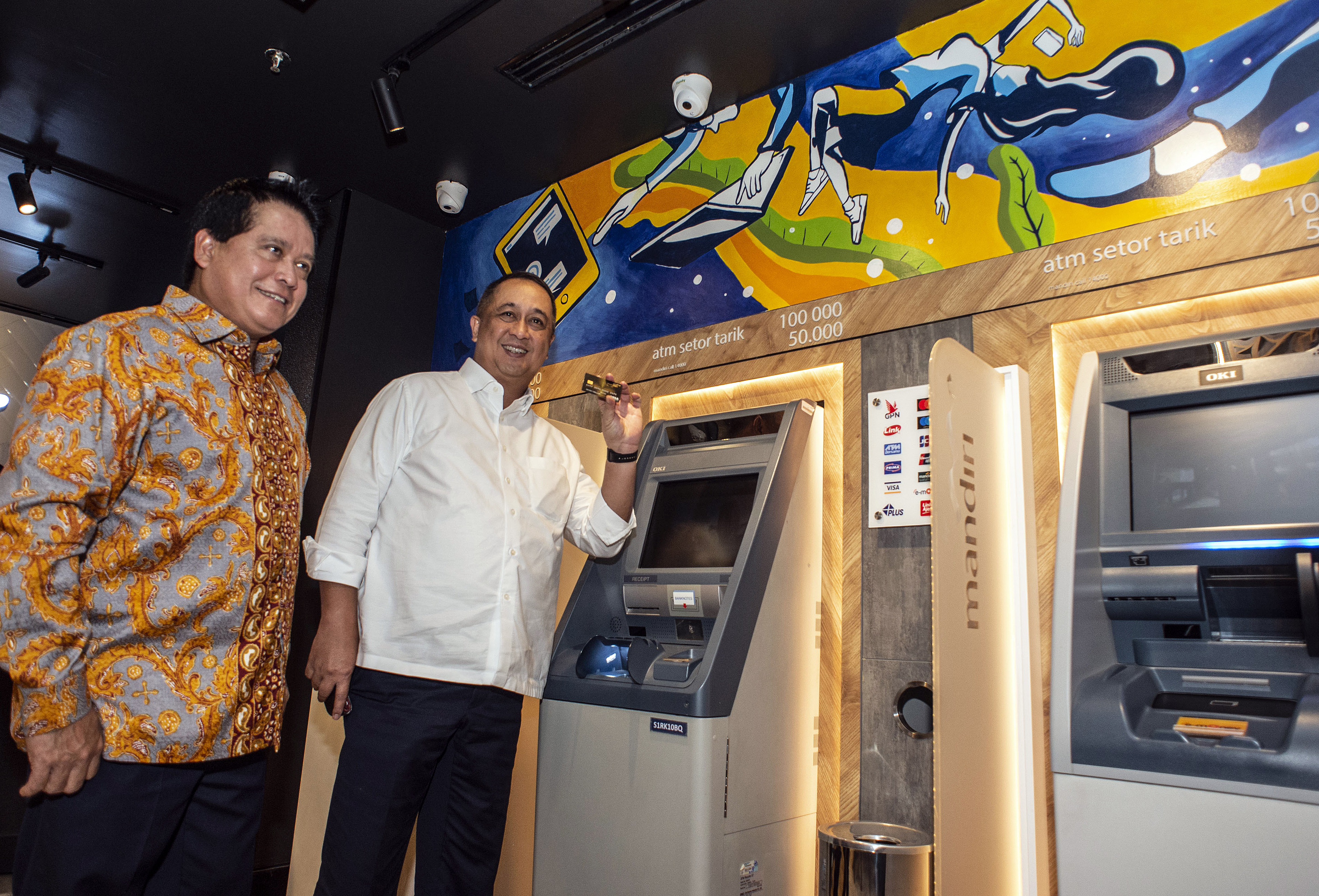 Direktur Utama Bank Mandiri Royke Tumilaar (kanan) bersama Wakil Direktur Utama Hery Gunardi mencoba mesin ATM.