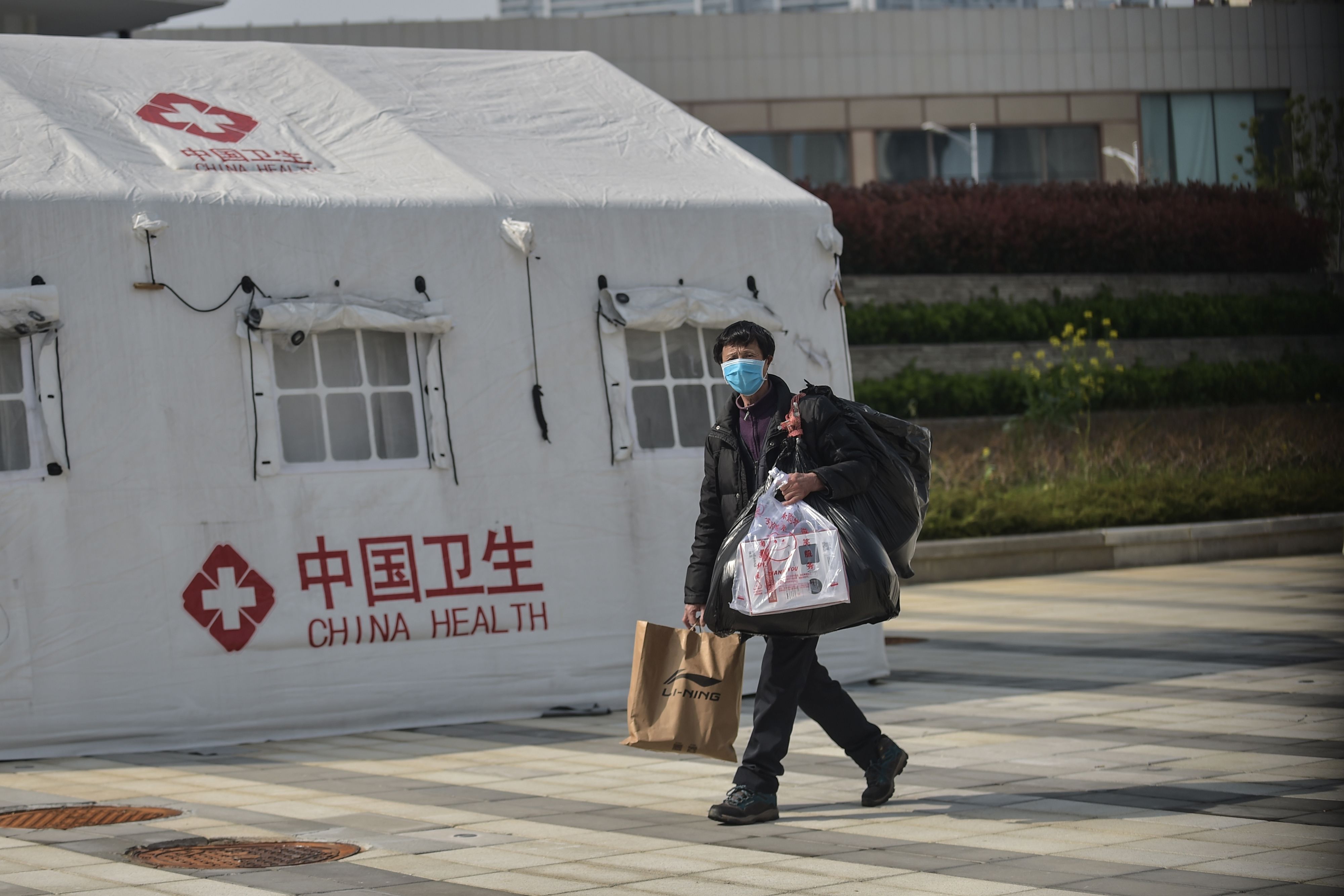 Seorang pria telah sembuh dari infeksi virus korona infection meninggalkan rumah sakit di Wuhan, Hubei, Tiongkok, Rabu (10/3/2020). 