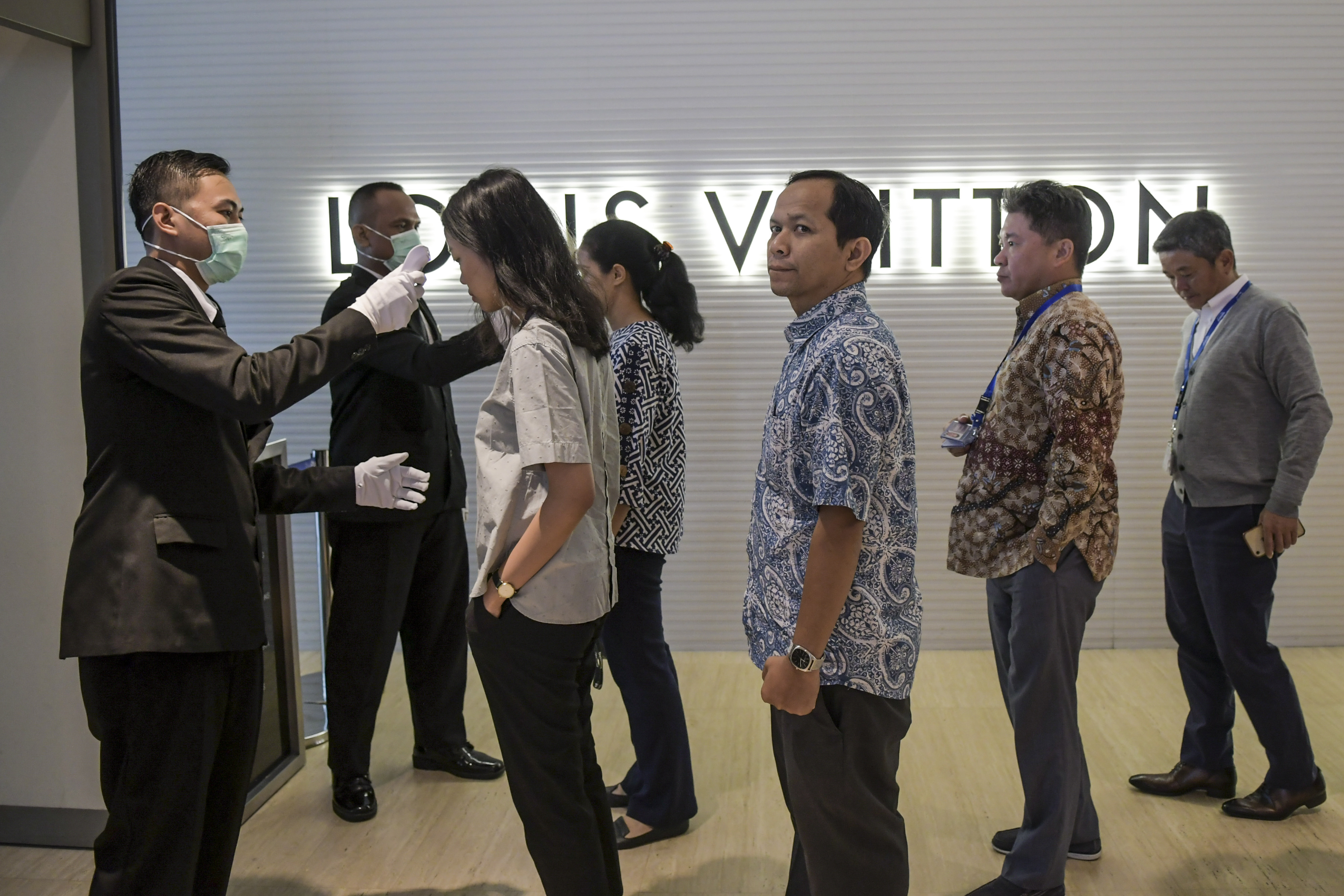 Petugas memeriksa suhu tubuh pengunjung pusat perbelanjaan Plaza Indonesia di Jakarta, Kamis (5/3/2020).