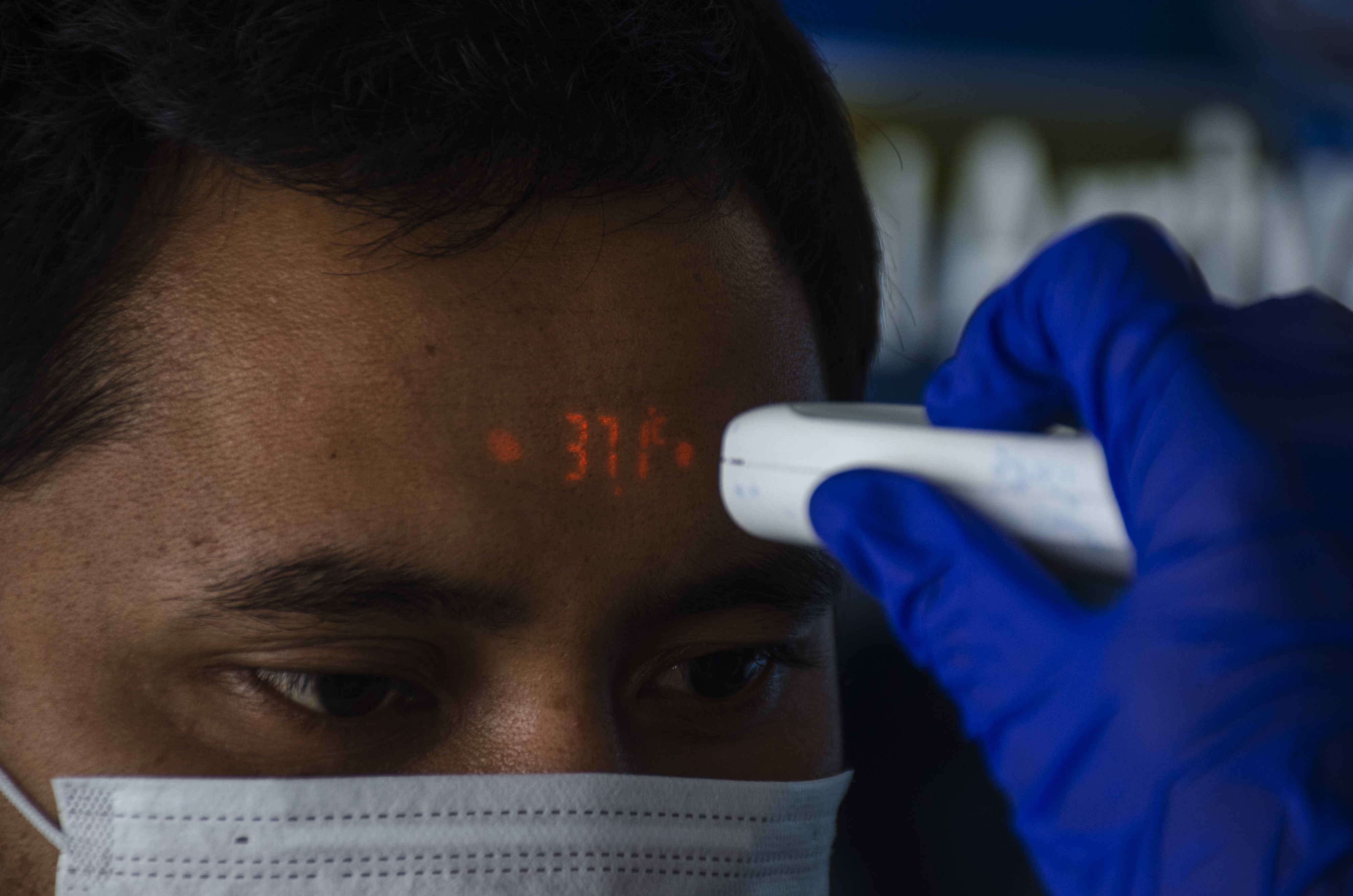 Petugas Kesehatan melakukan pengecekan suhu tubuh karyawan di Bandara Husein Sastranegara, Bandung.