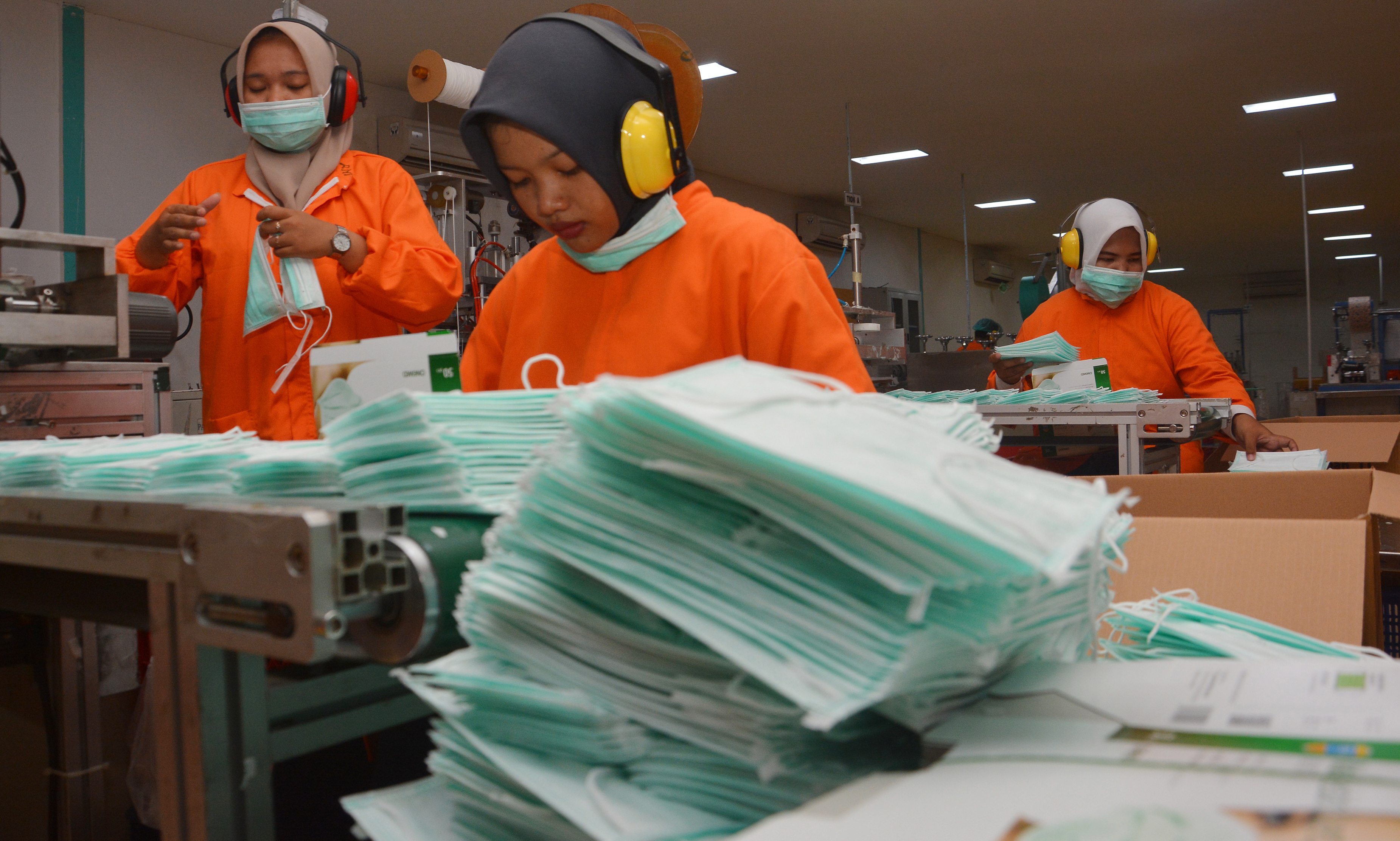 Buruh menyelesaikan pembuatan masker di PT Jayamas Medica Desa Karangwinongan, Kecamatan Mojoagung, Kabupaten Jombang, Jawa Timur.