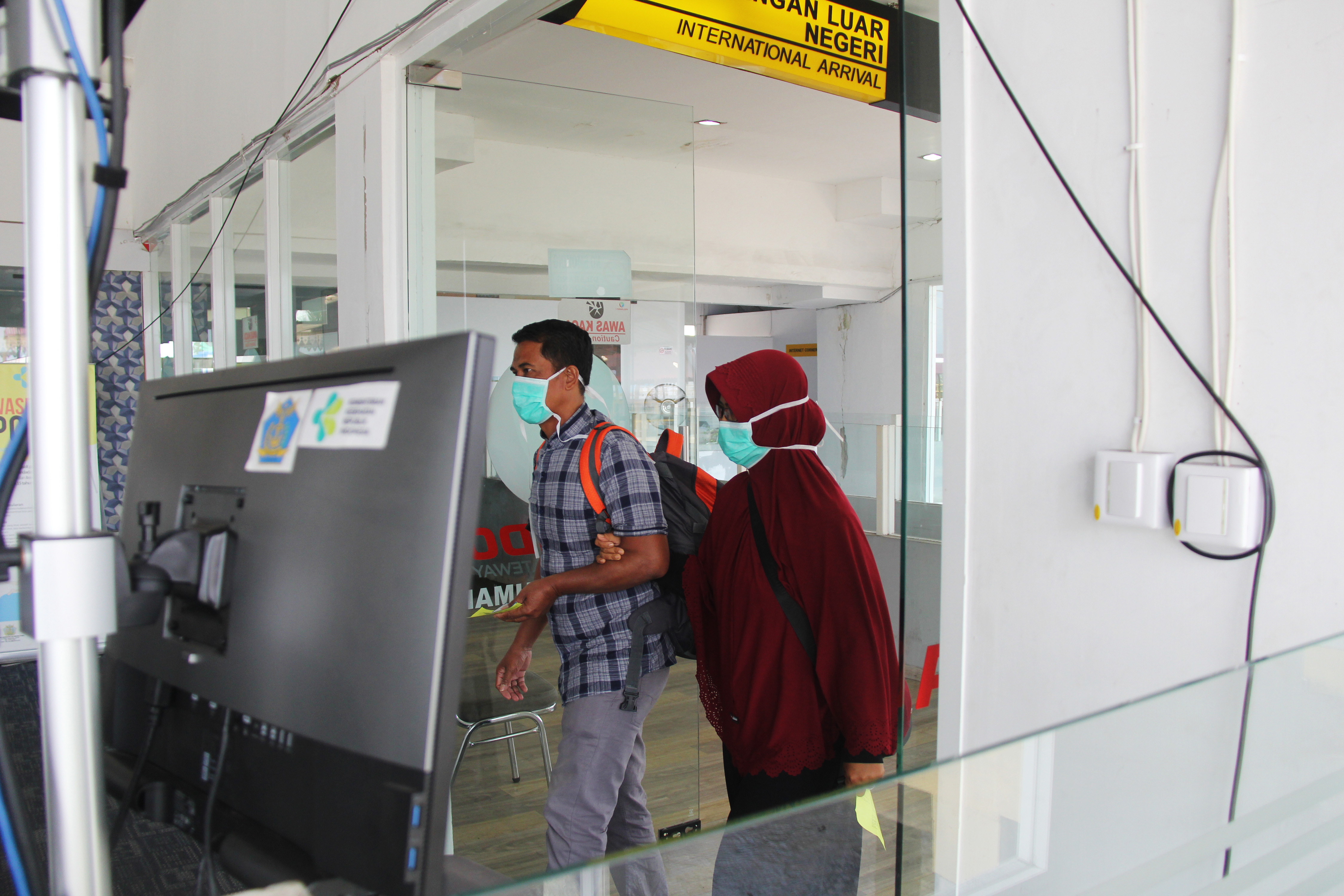 Sejumlah penumpang kapal dari Malaysia berjalan menuju terminal kedatangan Pelabuhan Internasional PT Pelindo I Dumai di Dumai, Riau.