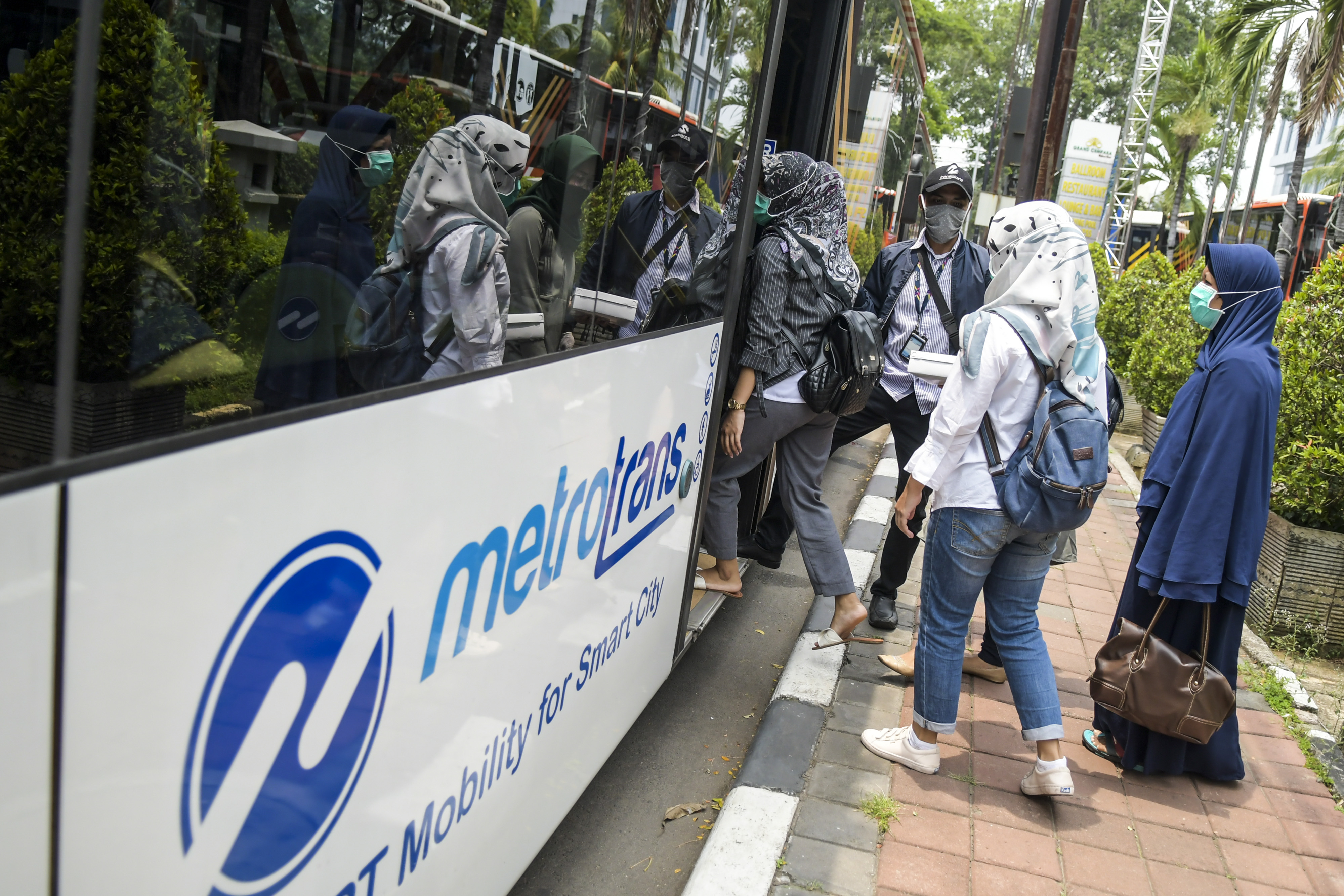 Petugas Medis masuk ke dalam bus Transjakarta di Hotel Grand Cempaka Bisnis, Jakarta.