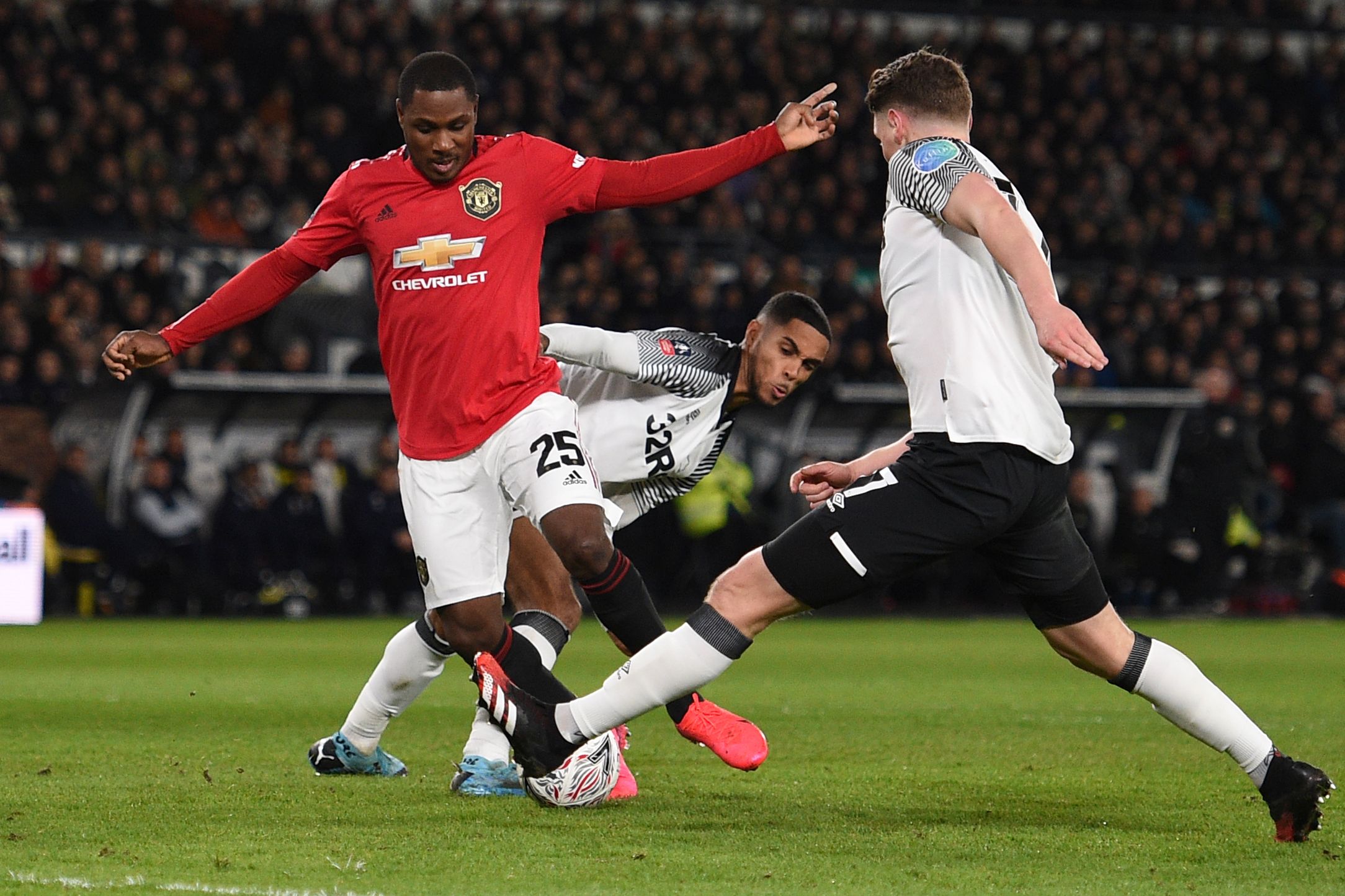Penyerang Manchester United Odion Ighalo (tengah) berusaha melewati hadangan dua pemain Derby County