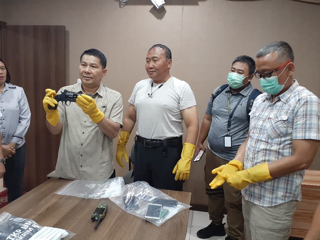 Ketua Ops Nemangkawi Brigjen Pol. Roycke Harry Langie sedang memegang barang bukti senjata api.