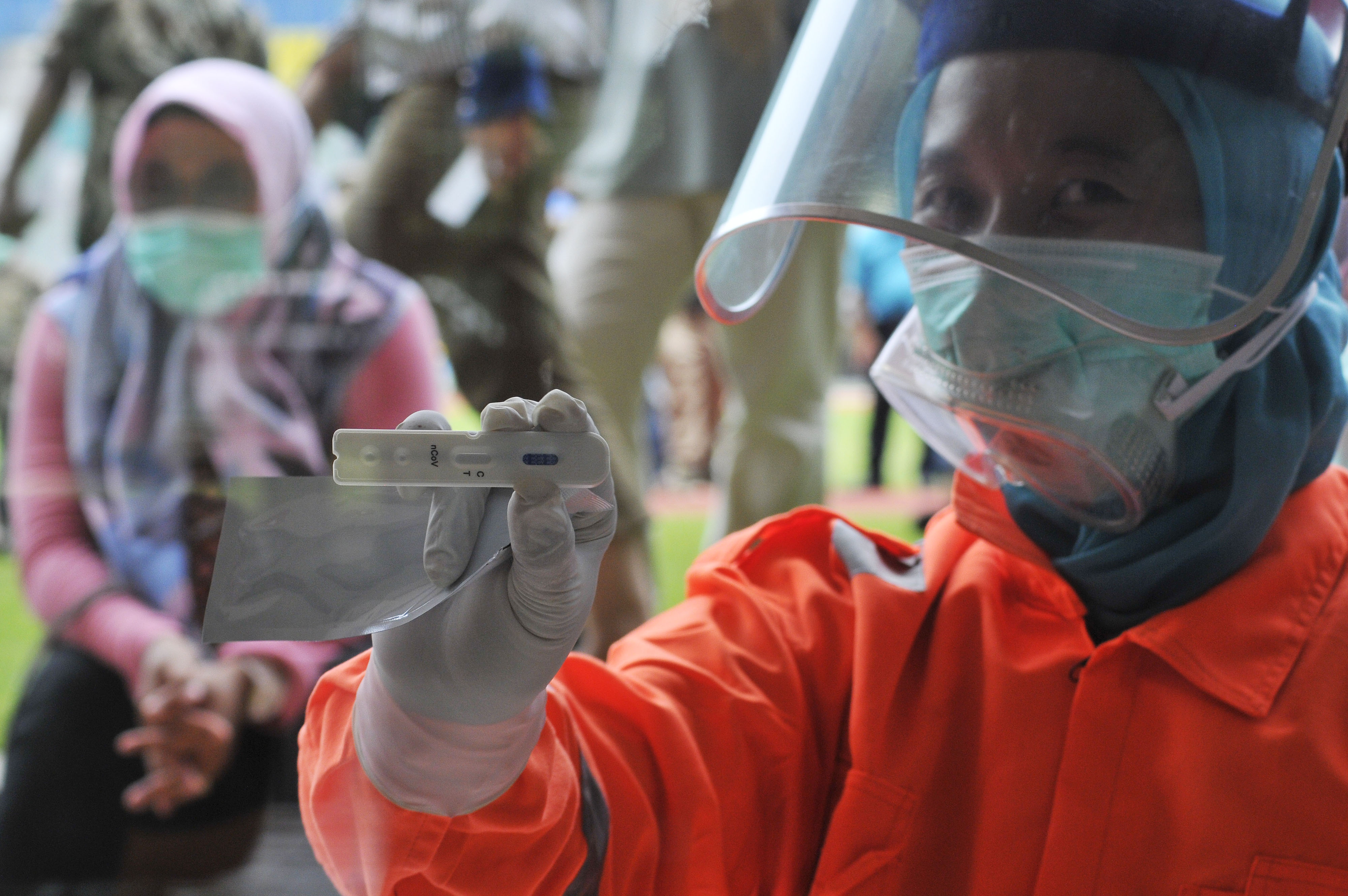 Petugas memperlihatkan alat tes cepat. 