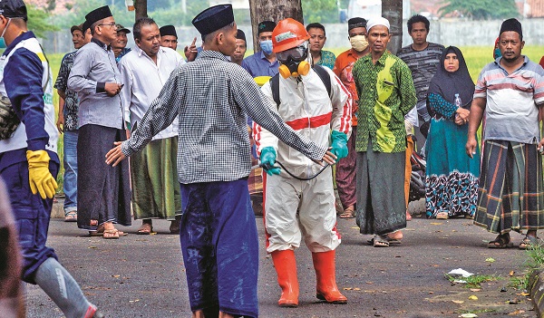 Petugas menyemprotkan cairan disinfektan kepada santri yang baru datang di Kabupaten Pekalongan, Jawa Tengah, Selasa (31/3/2020)