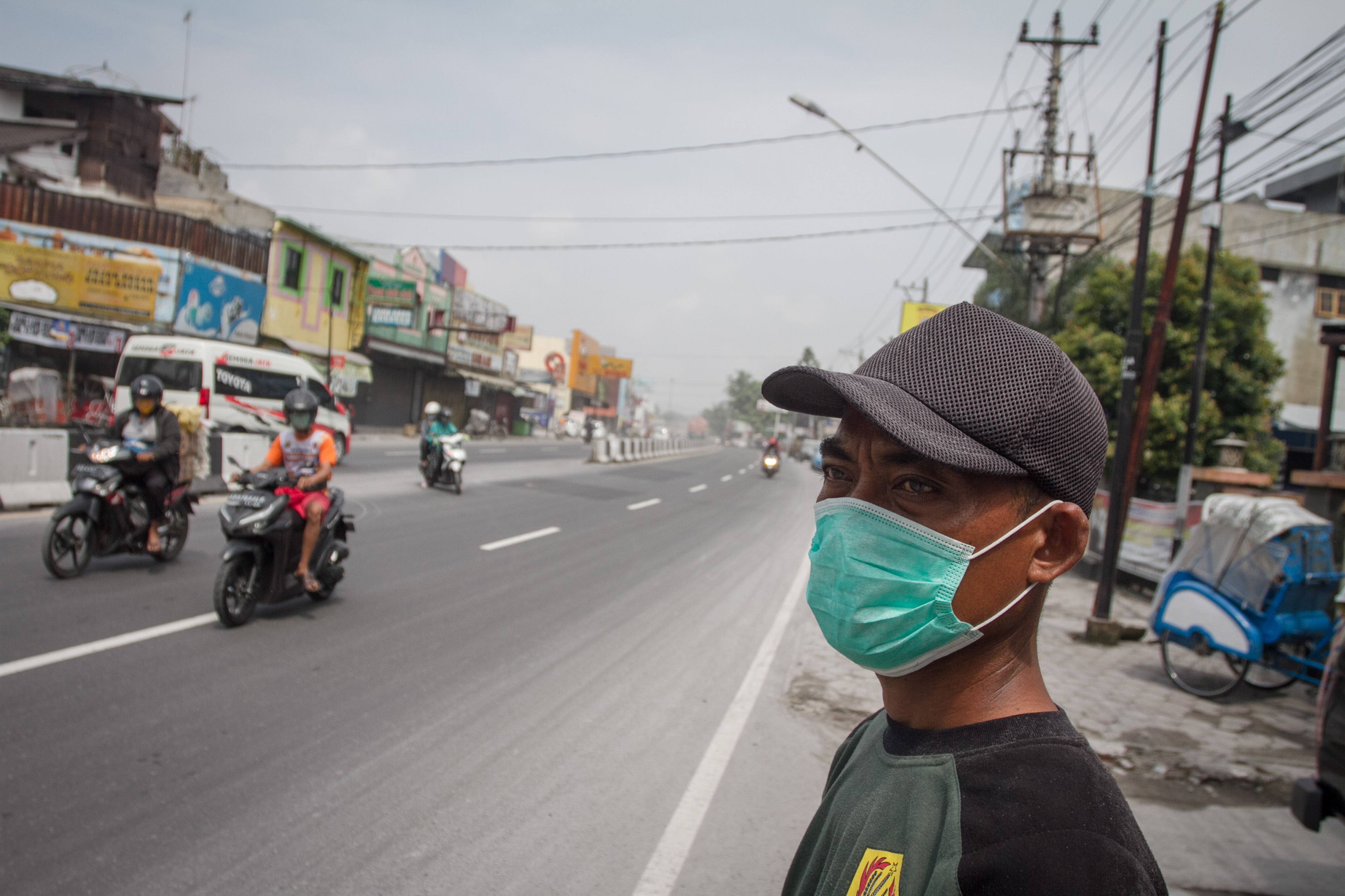 Warga beraktivitas dengan mengenakan masker saat hujan abu di Kartasura, Sukoharjo, Jawa Tengah, Selasa (3/3/2020)