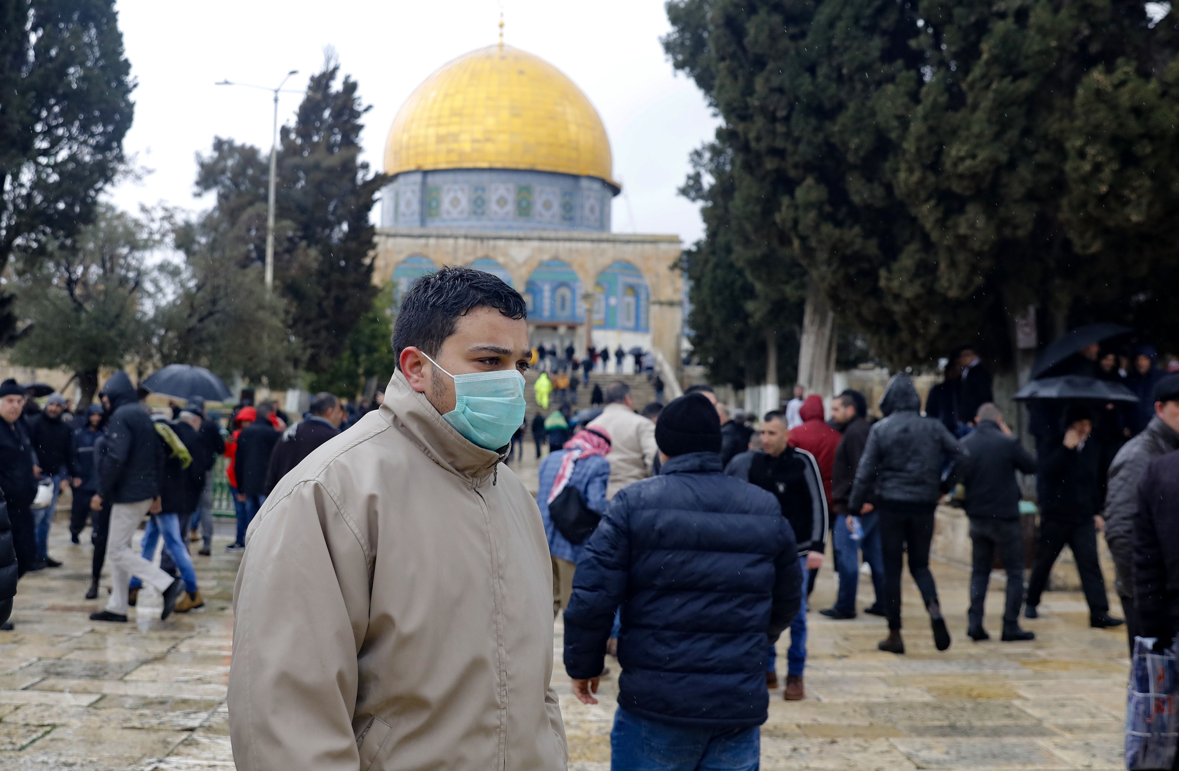 Warga mengenakan masker saat berjalan di depan Masjid Al-Aqsa, Jerusalem.