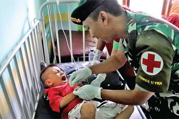 Petugas medis dari TNI-AD menginfus balita yang dirawat akibat demam berdarah (DB) di Puskesmas Nita di Kecamatan Nita, Sikka, NTT, kemarin.