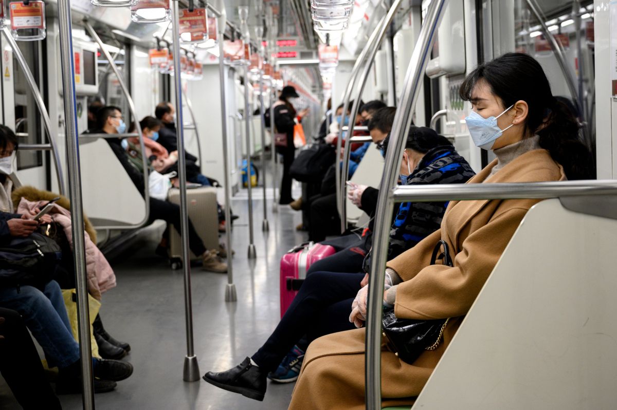 Warga mengenakan masker saat menumpangi kereta di Shanghai, Tiongkok.