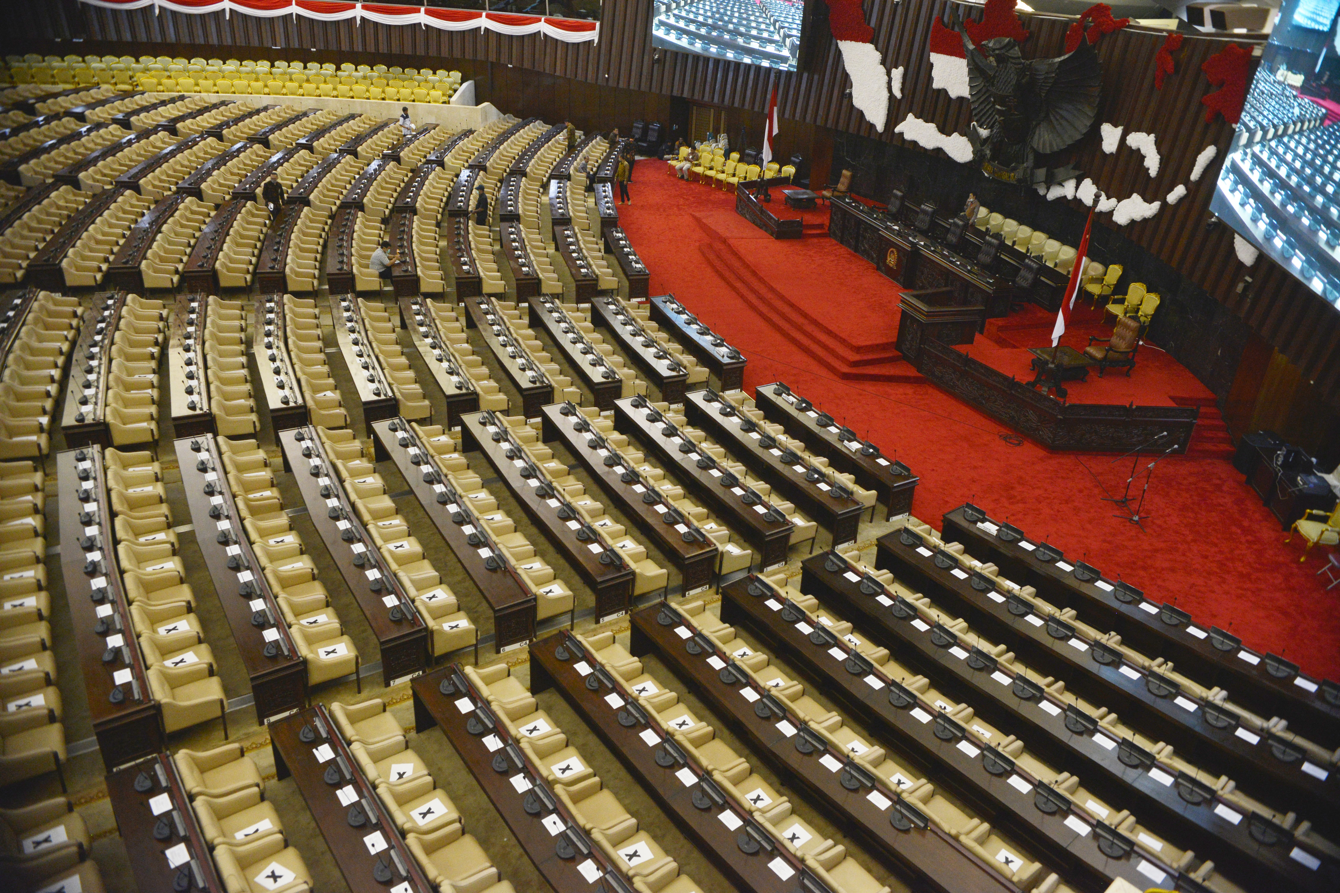 Staf Kesekjenan DPR-RI memasang lembaran tanda silang untuk atur jarak antar anggota Dewan dalam Pembukaan masa Sidang, pekan depan.