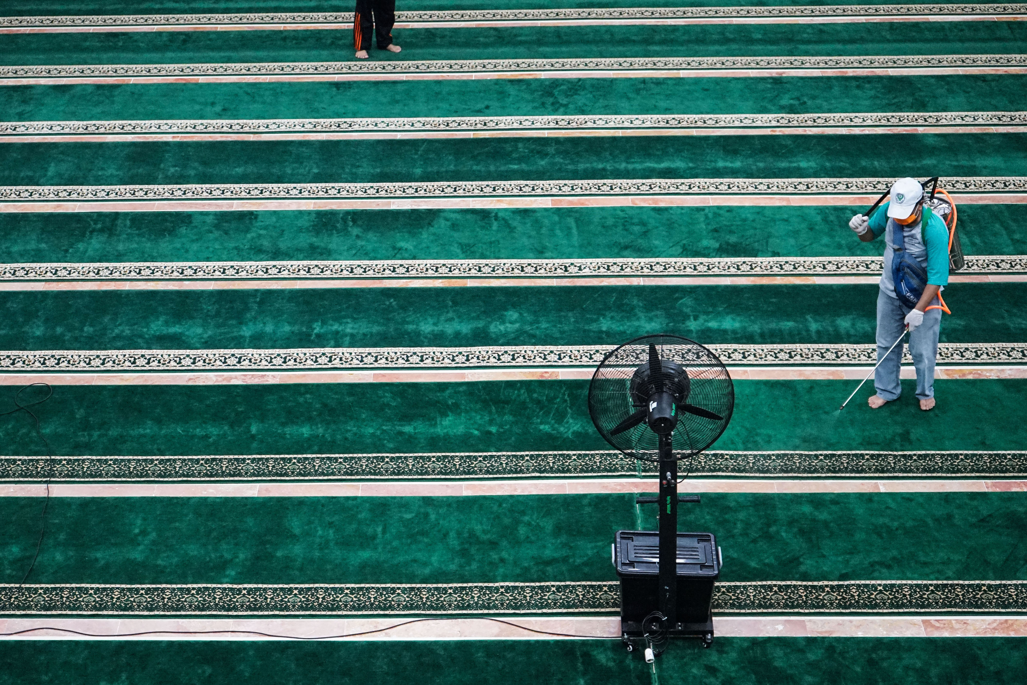 Petugas Kantor Kesehatan Pelabuhan (KKP) Kelas III Palangkaraya menyemprotkan cairan disinfektan di Masjid Raya Darussalam, Palangkaraya, 
