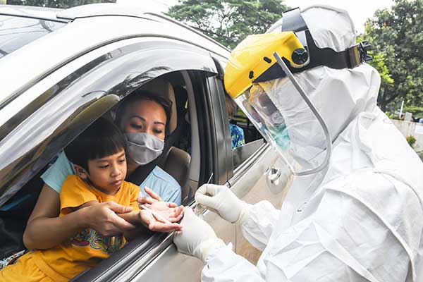 Petugas Dinkes Kota Depok mengecek pengguna kendaraan saat tes cepat (rapid test) covid-19 sistem drive thru di Cimanggis, Depok, kemarin.