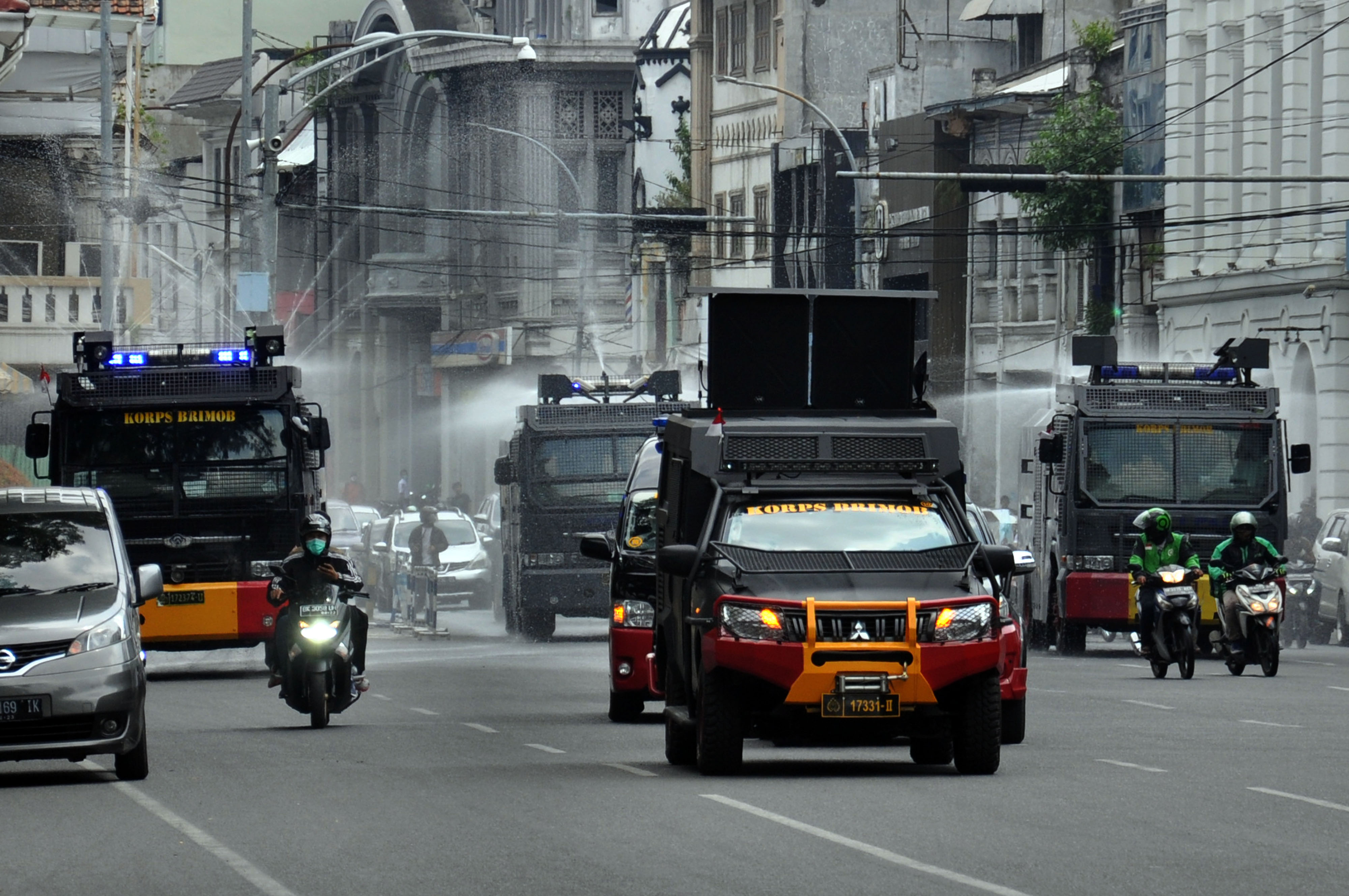 Personel Polda Sumut menyemprotkan cairan disinfektan dengan menggunakan mobil water canon di Medan