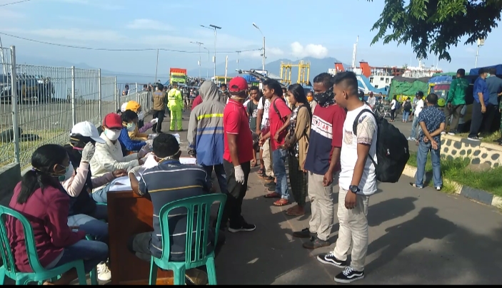 Petugas memeriksa suhu badan penumpang di Pelabuhan ASDP Fery Larantuka, Jumat (27/3/2020).
