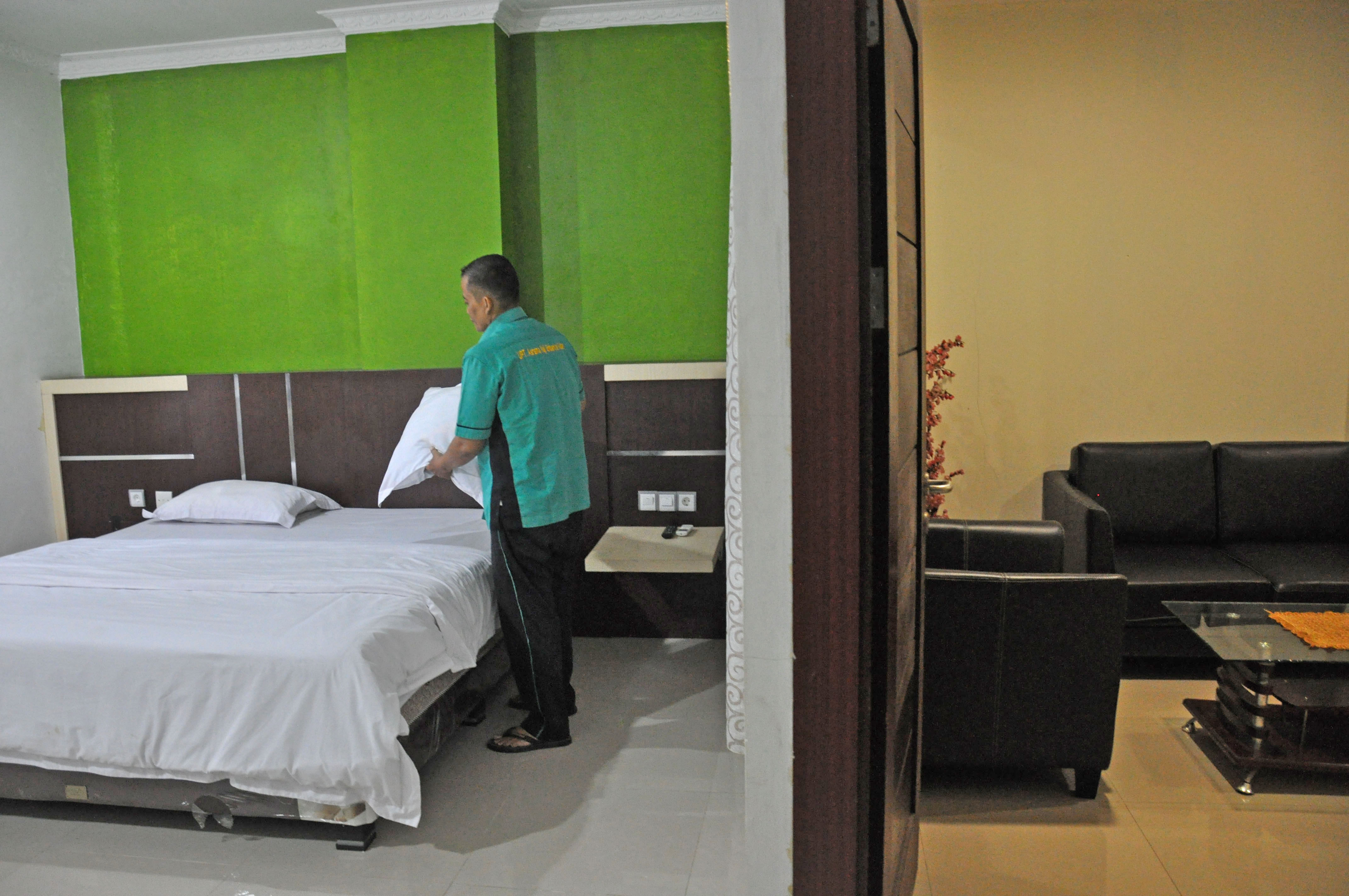 Petugas membersihkan kamar di asrama haji Medan, Sumatra Utara