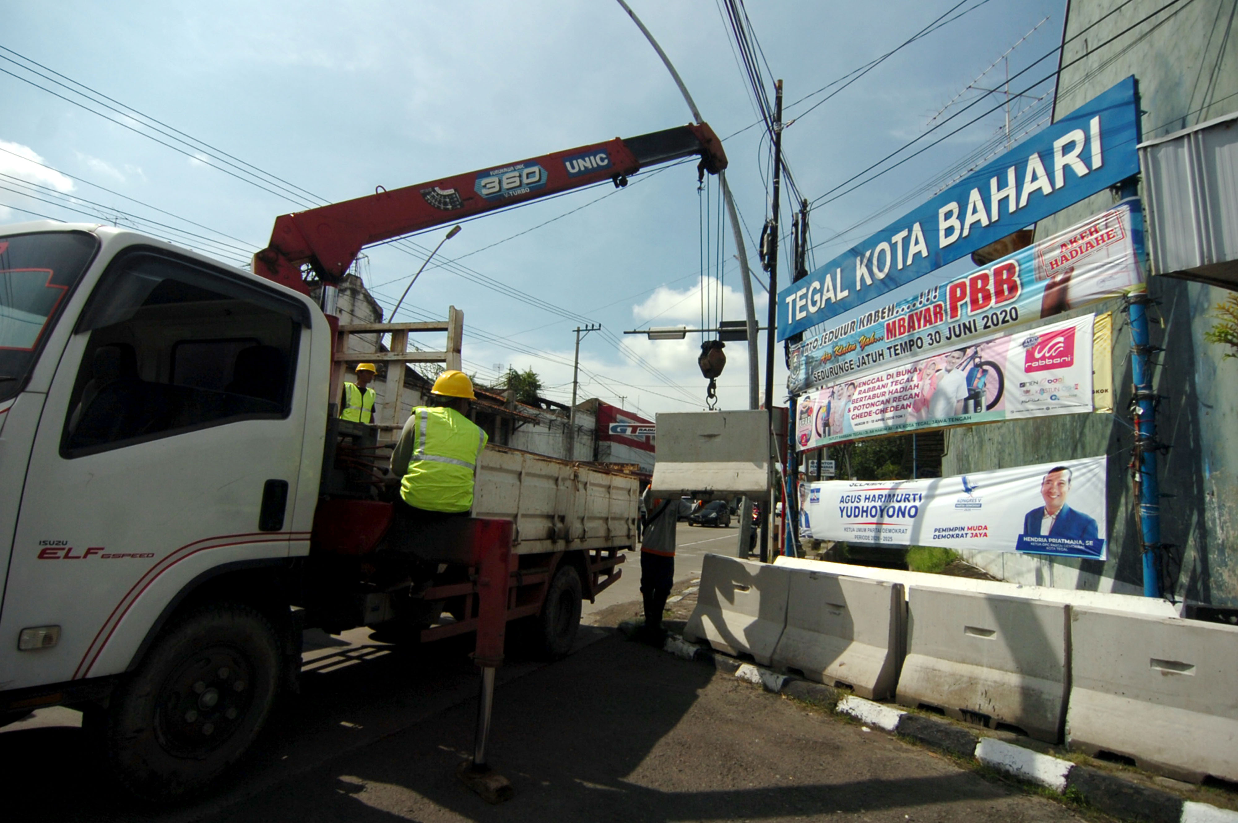 Pekerja melakukan proses penurunan beton movable concrete barrier saat persiapan penutupan jalan di jalur Pantura Gajah Mada, Tegal, Sabtu (