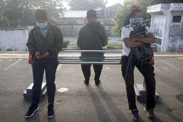 Penumpang menjaga jarak  saat menunggu jadwal keberangkatan Commuter Line di Stasiun Depok Lama, Selasa (24/3).